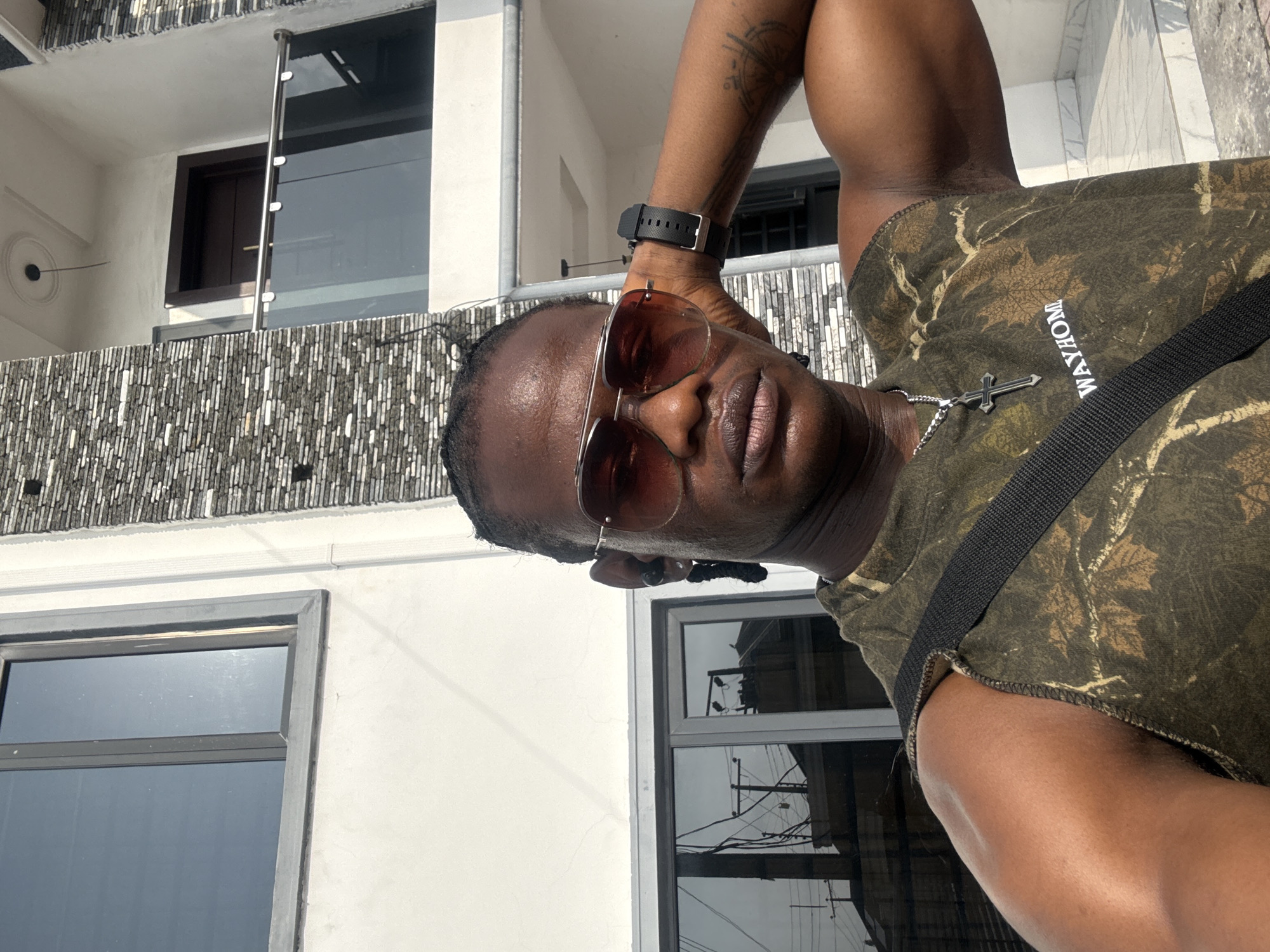 Man takes selfie outside modern building in Iranla, Nigeria