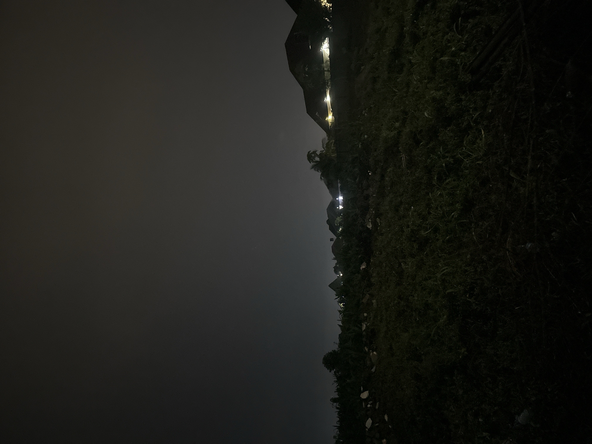 Wet Abuja streets and gated homes late on a rainy night