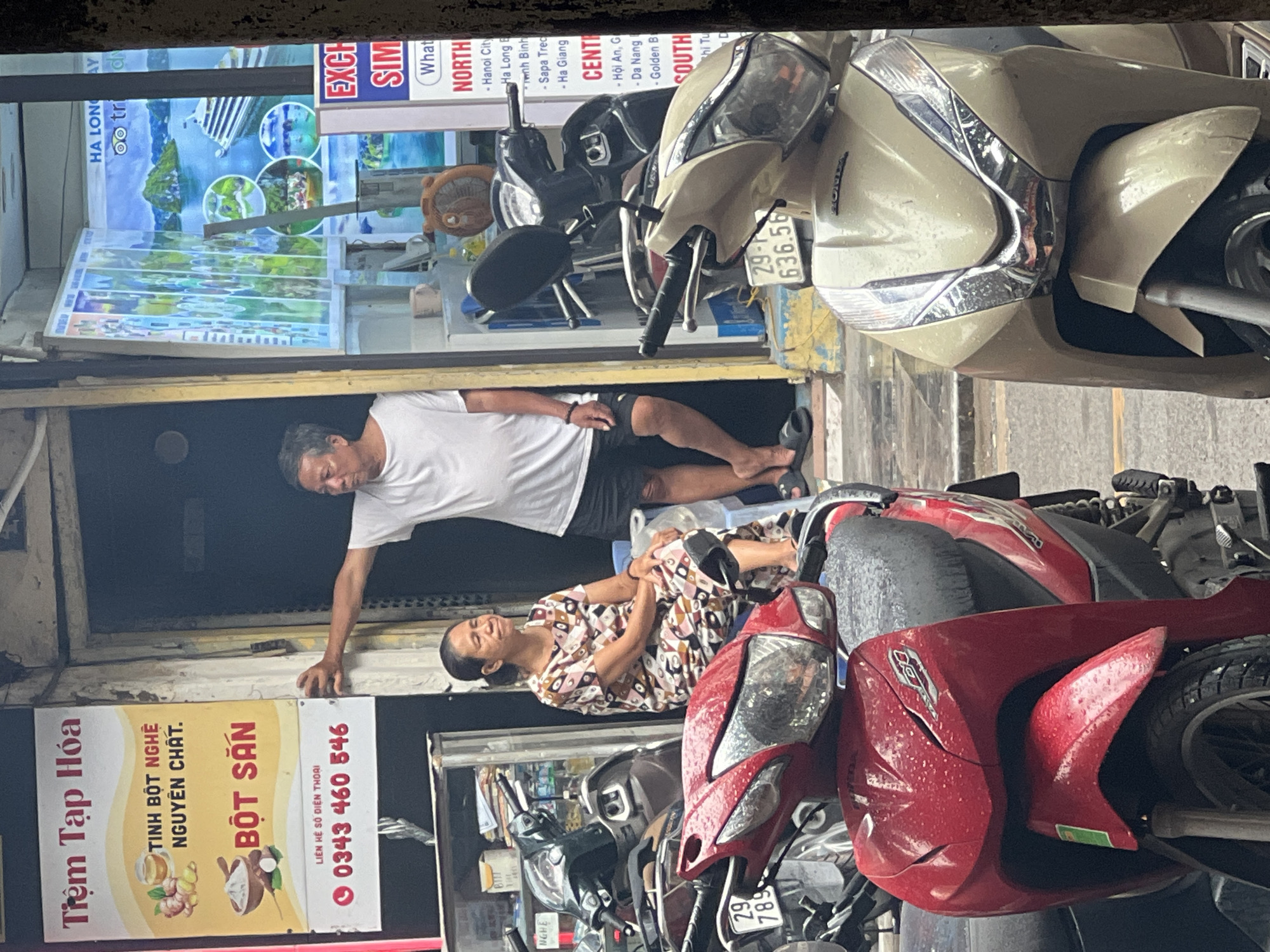 Wet streets and parked bikes outside Hanoi Old Quarter shops