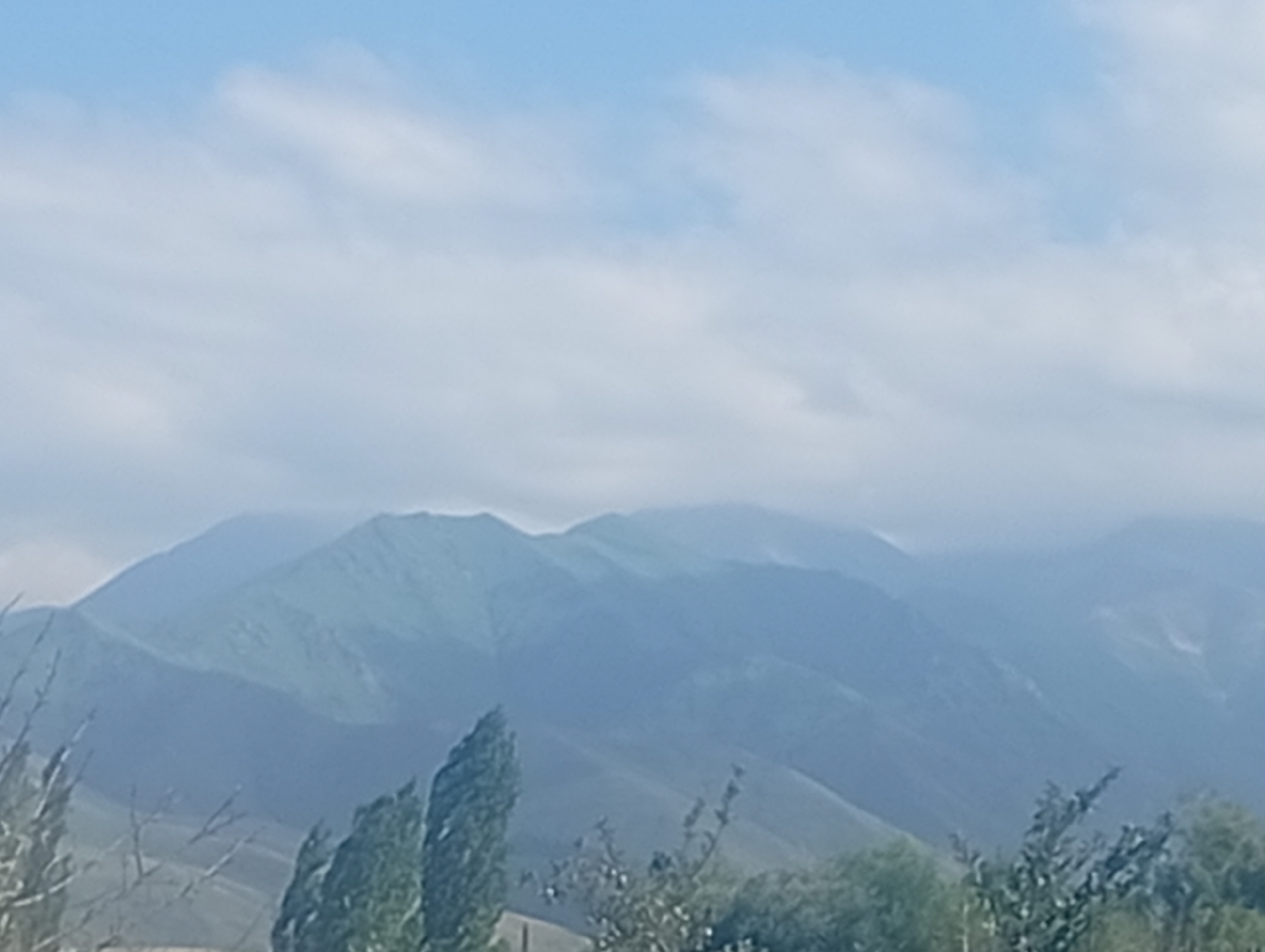 Hazy blue mountain ranges stretch out across Arashan, Kyrgyzstan