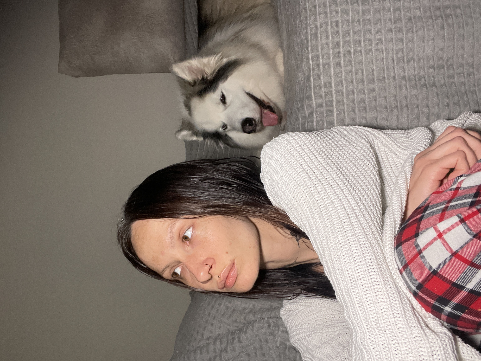 Woman rests with husky dog at home in Pervomaysky