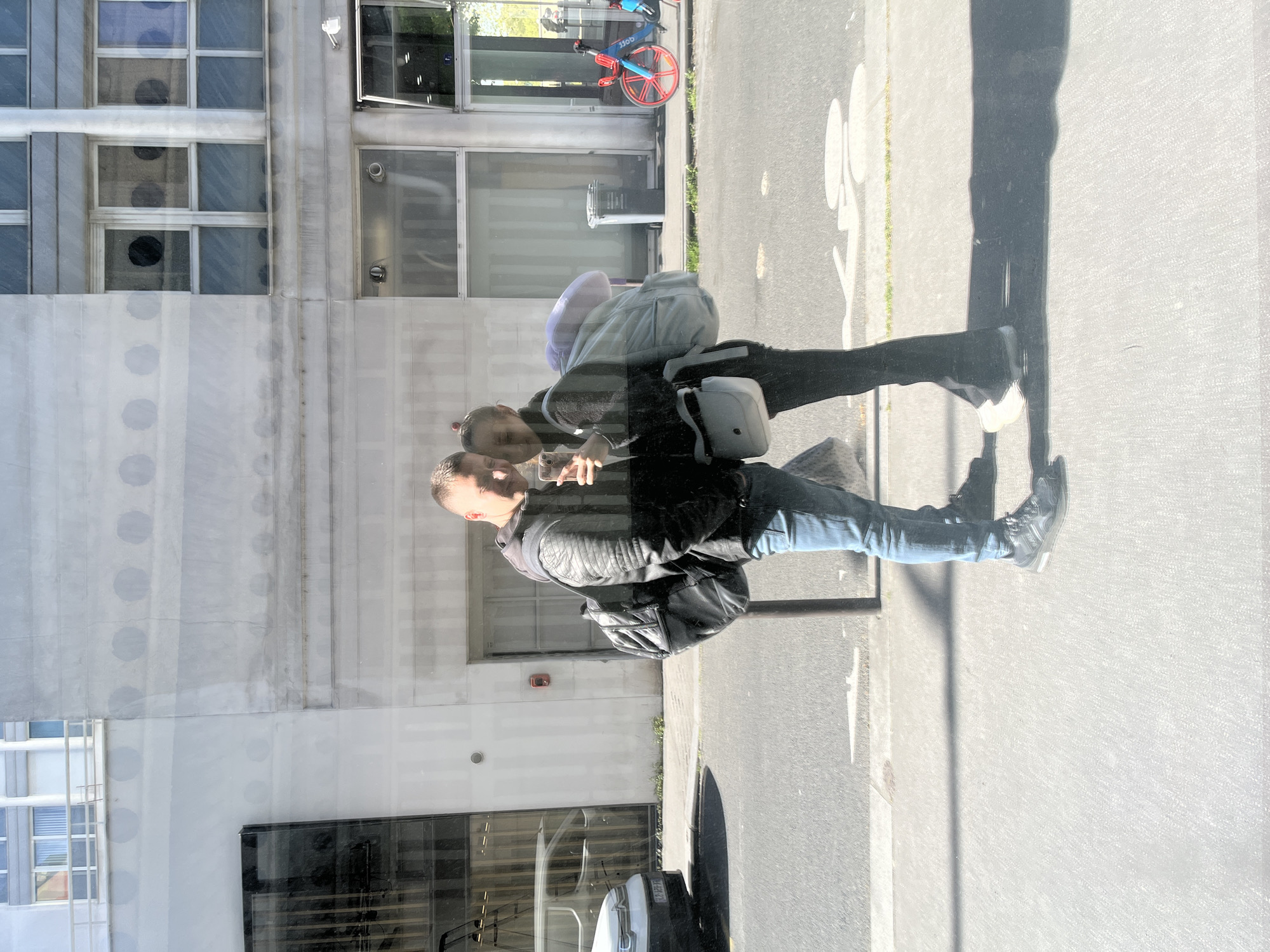 Couple reflected in Paris building glass on sunny afternoon