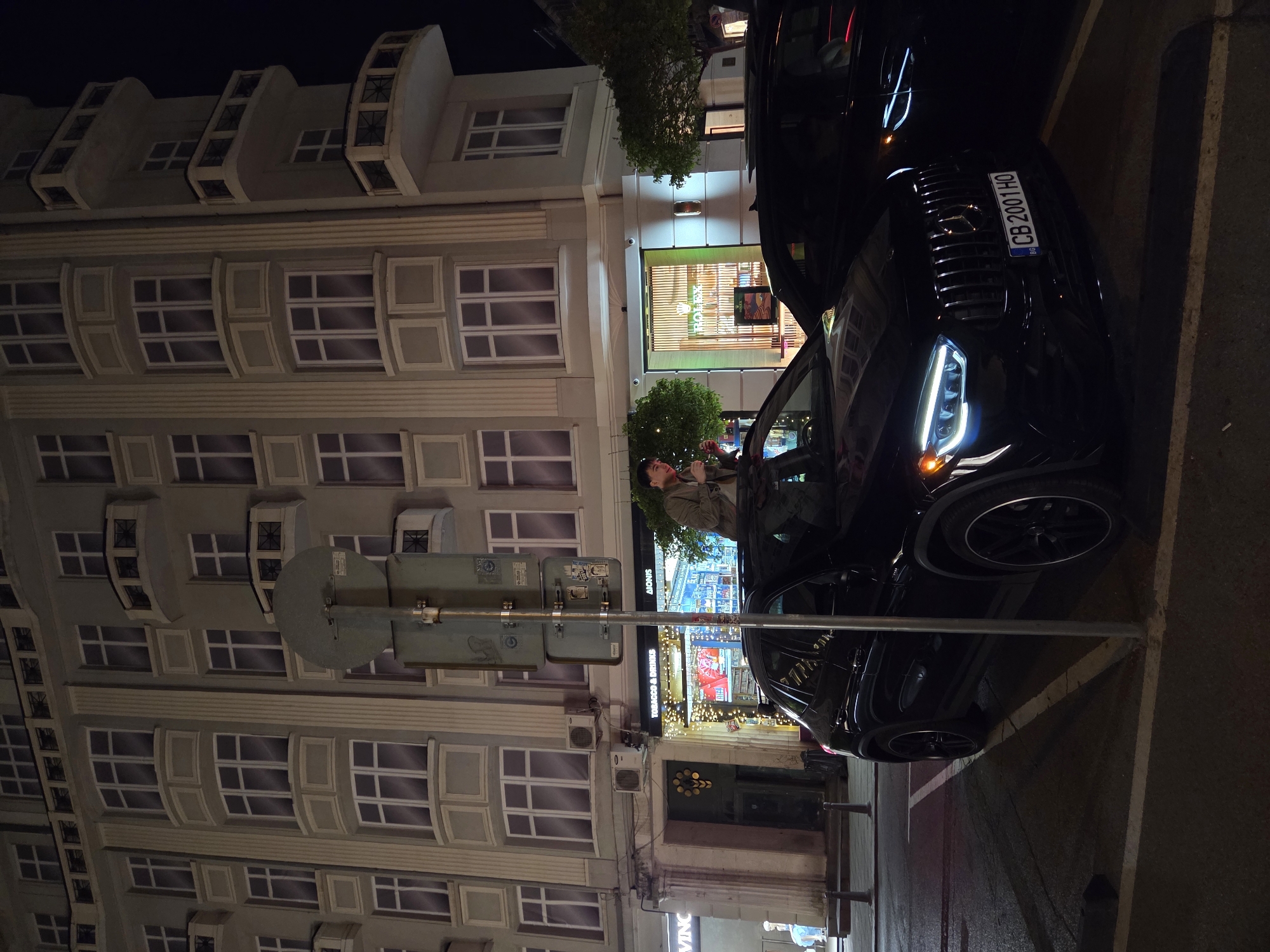 Men stand through sunroofs of luxury cars in Sofia