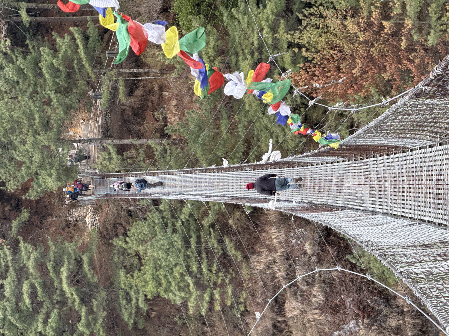 Hikers cross suspension bridges on Nepal mountain trails