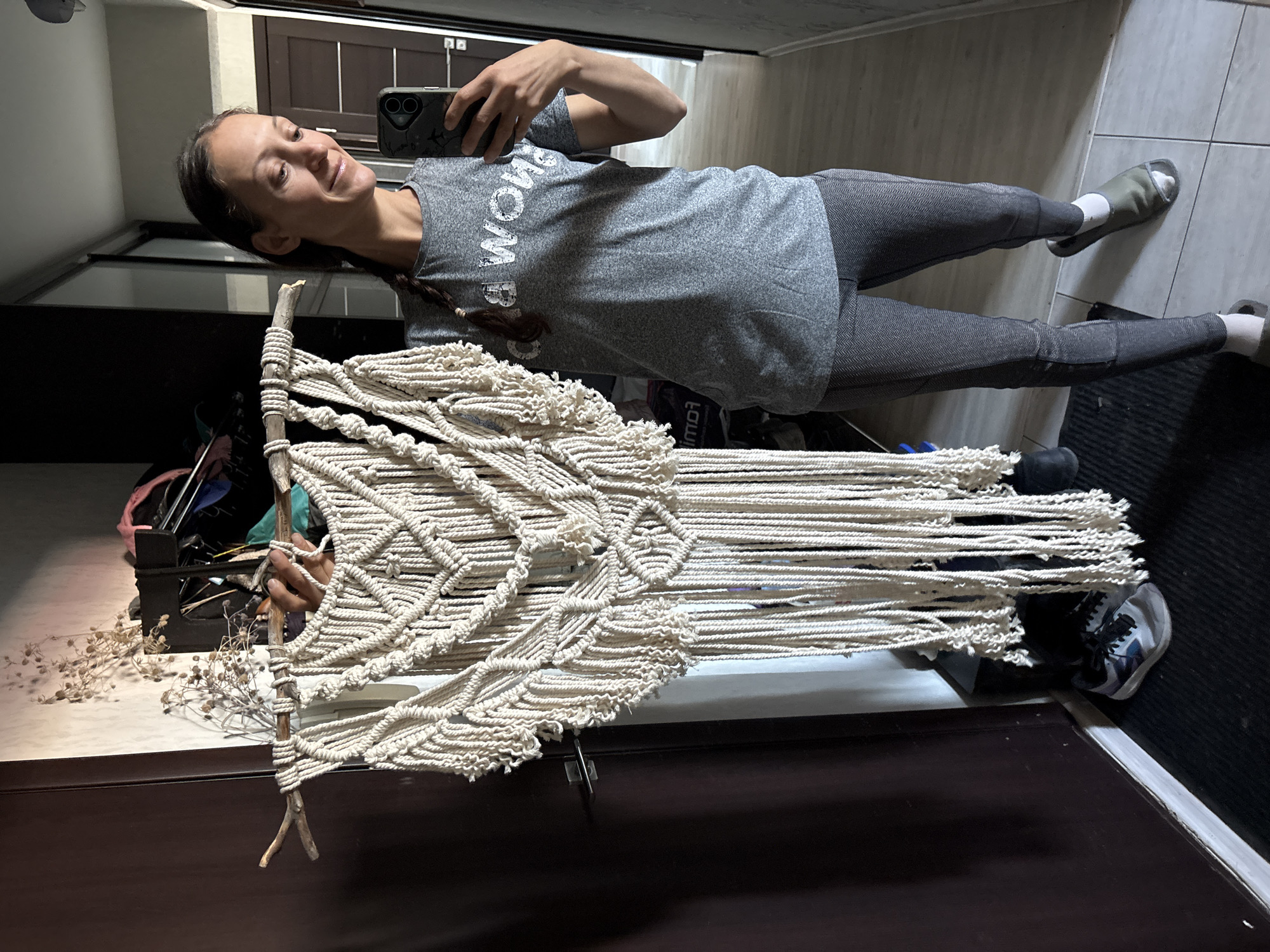Woman displays handmade macrame artwork in Ulyanovsk home