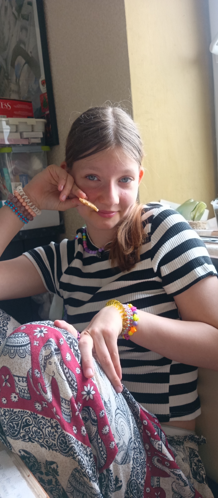 Teen photographed in striped shirt and elephant-patterned trousers indoors