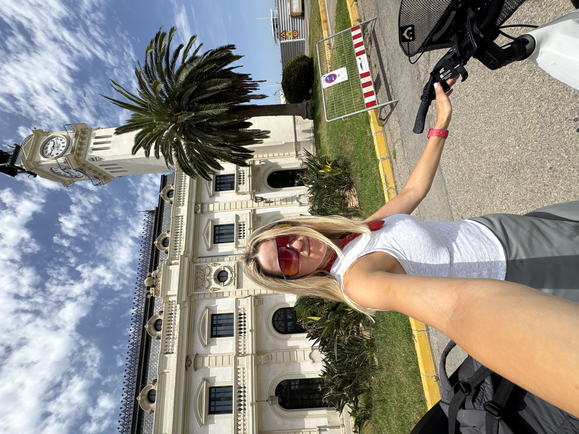 Pausing by a clock tower with a white e-bike in Valencia