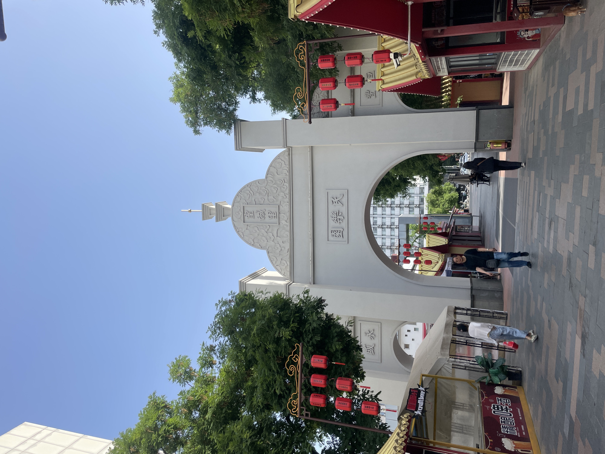Nighttime street activity recorded at decorated archway in Xincheng District