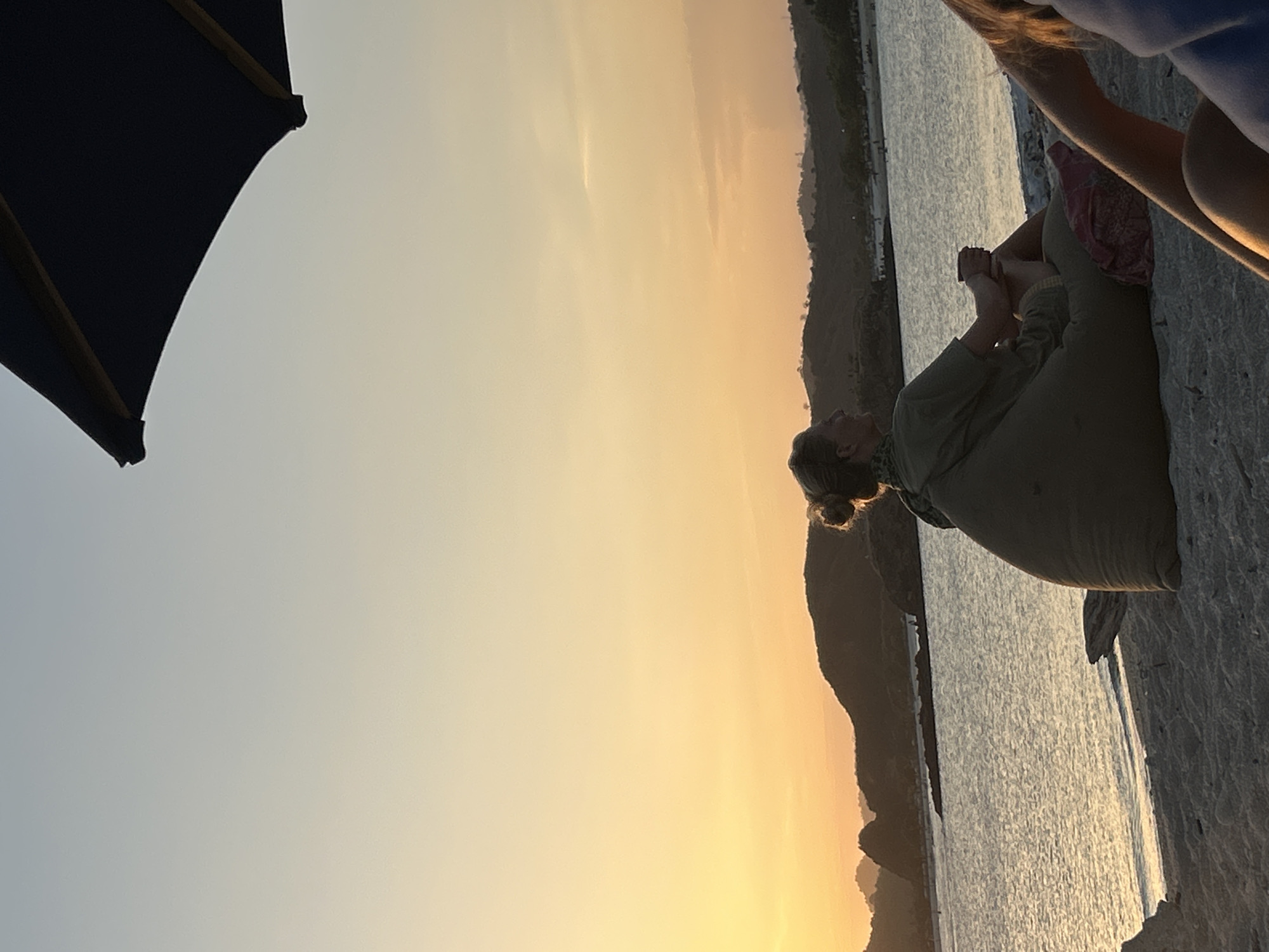 Kuta beach sunset, beanbag chairs, drinks, golden hour vibes.