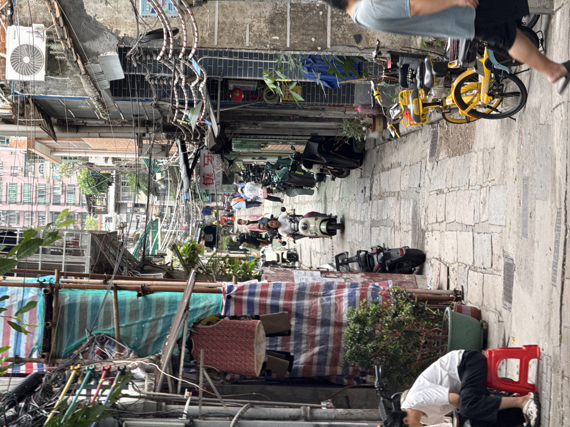 Motorbikes crowd narrow stone alley in Liwan District