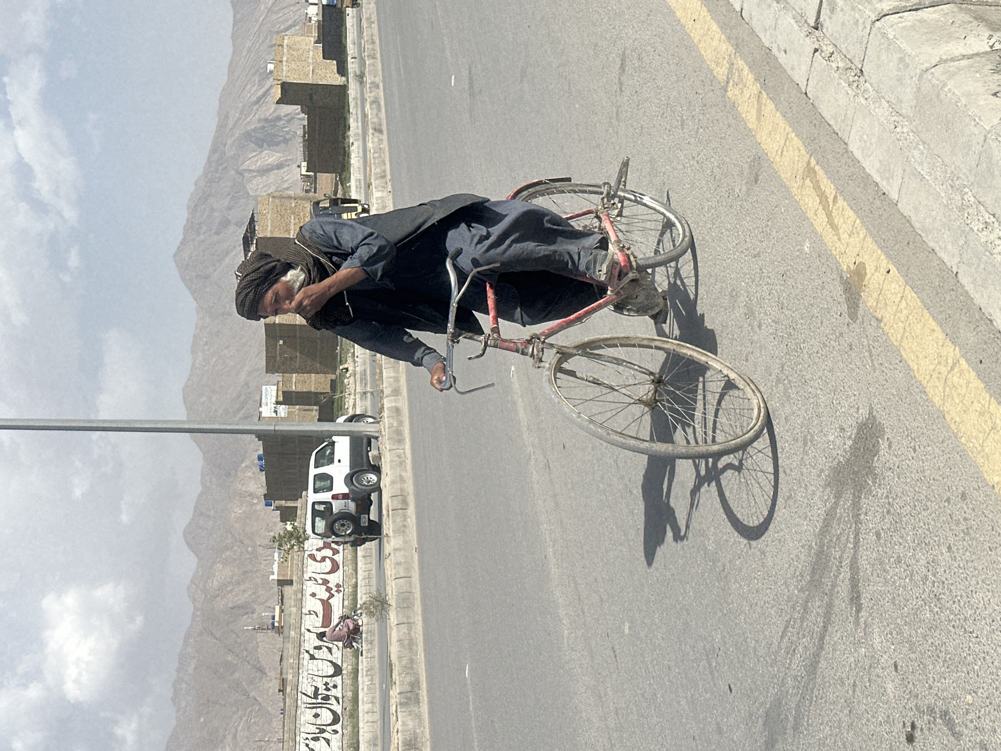 Cycling through Quetta in dark traditional dress