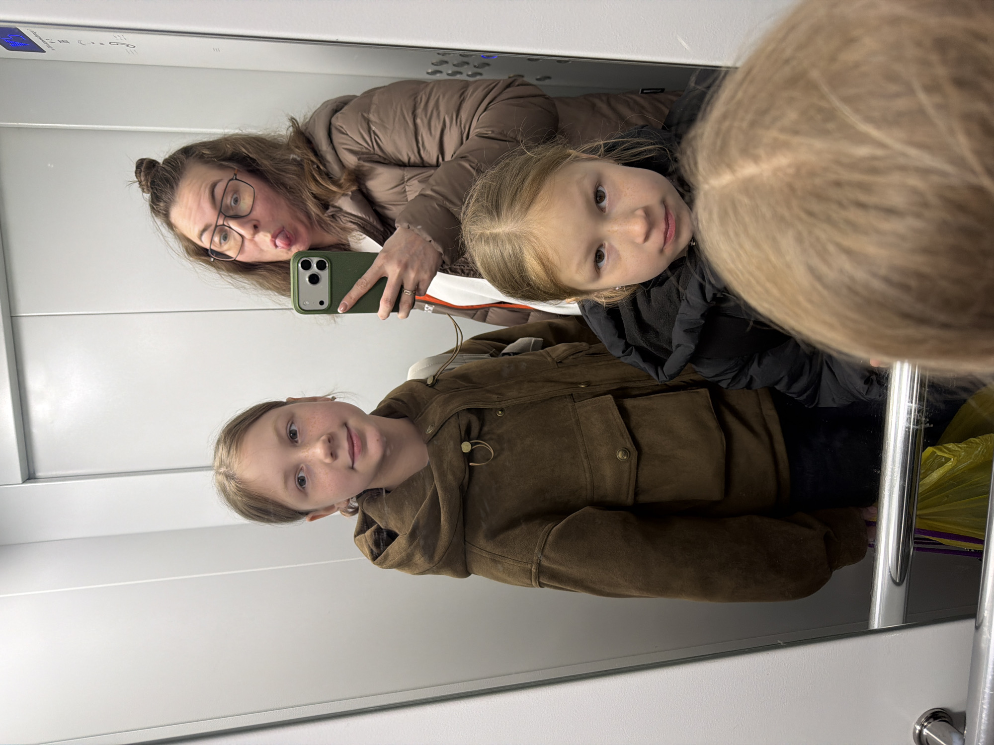 Family Takes Mirror Selfie in Elevator