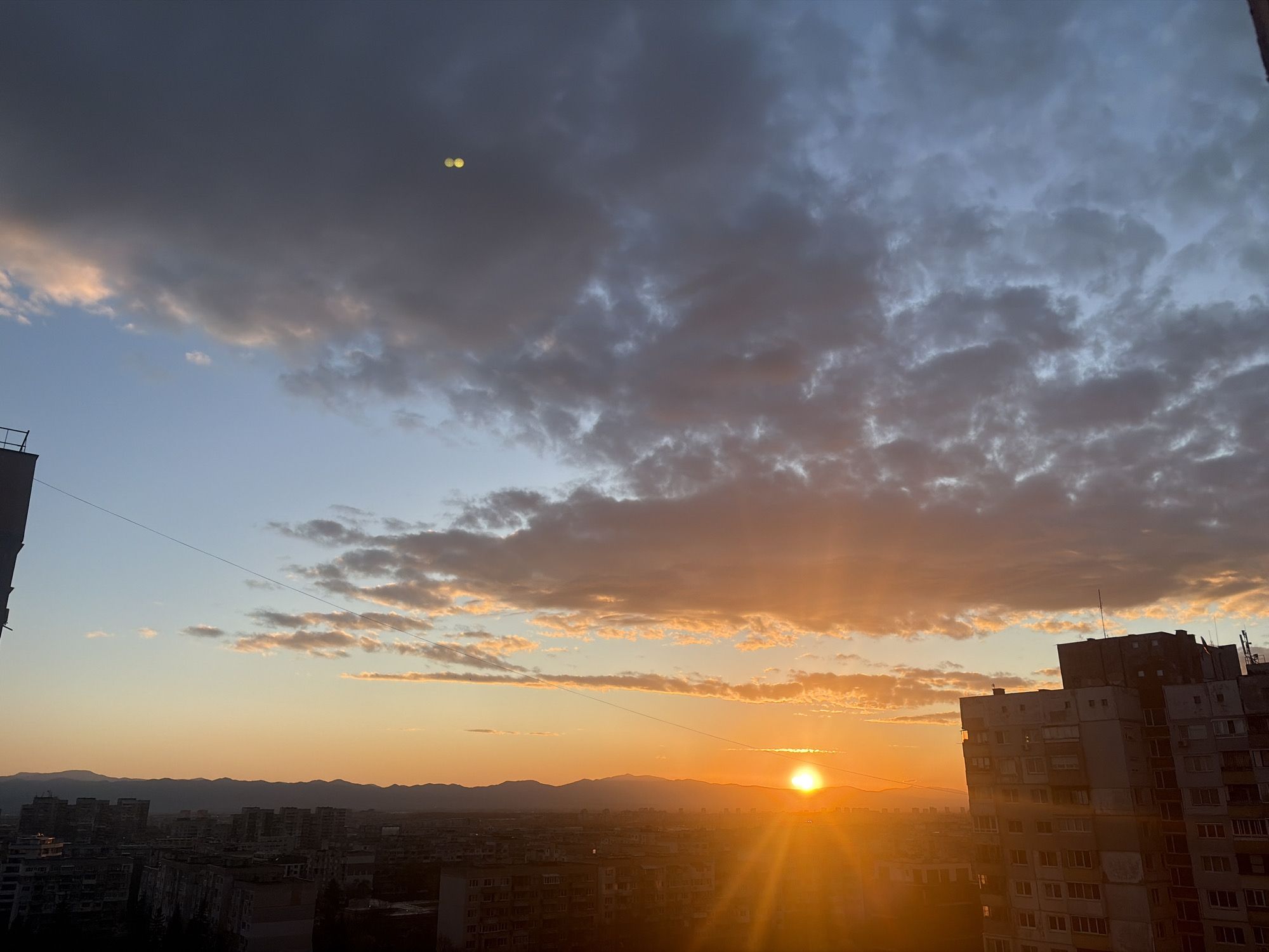Sunset observed over Sofia mountains with residential buildings visible