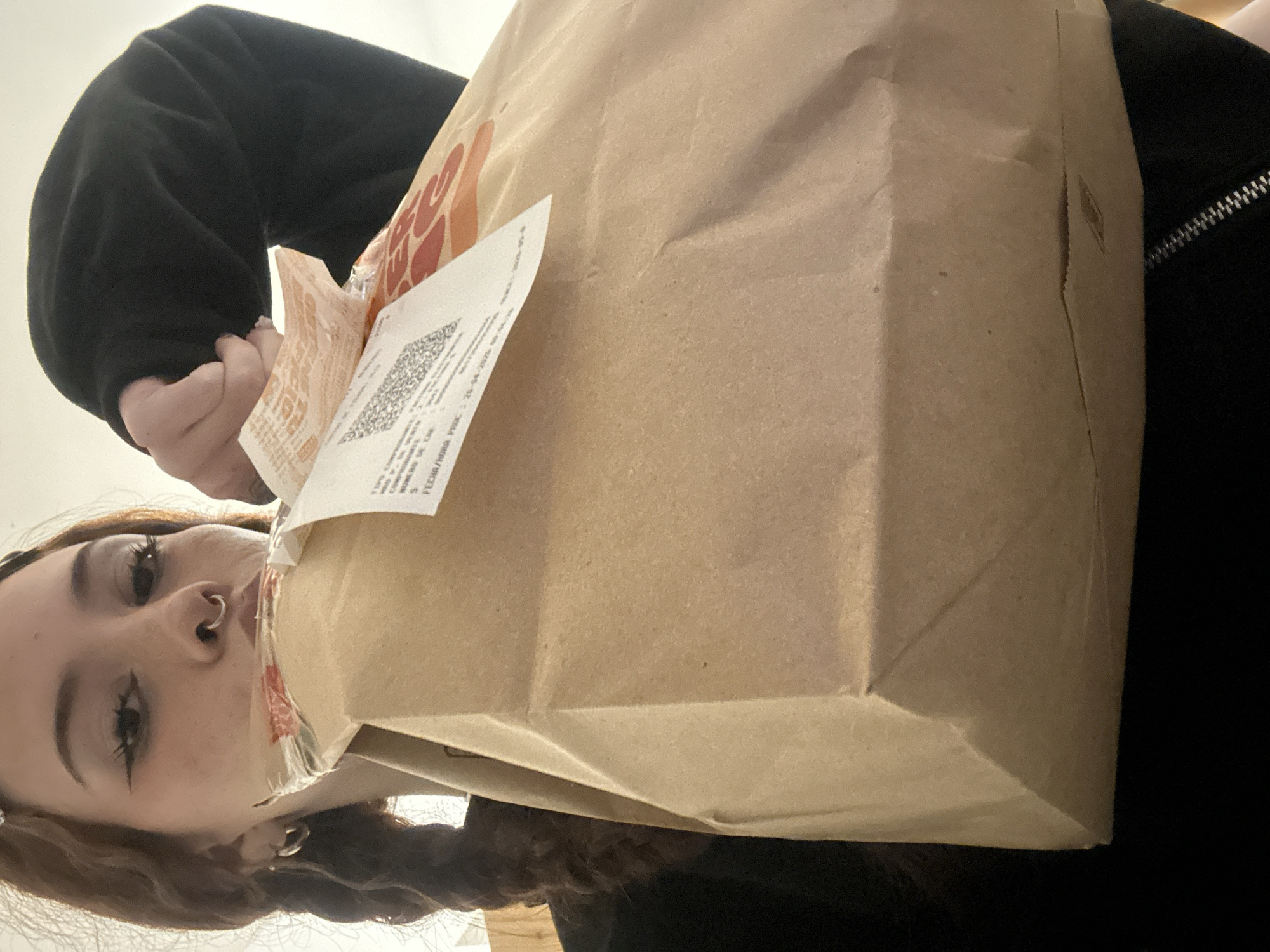 Person with piercings holds receipt bag in Buenos Aires