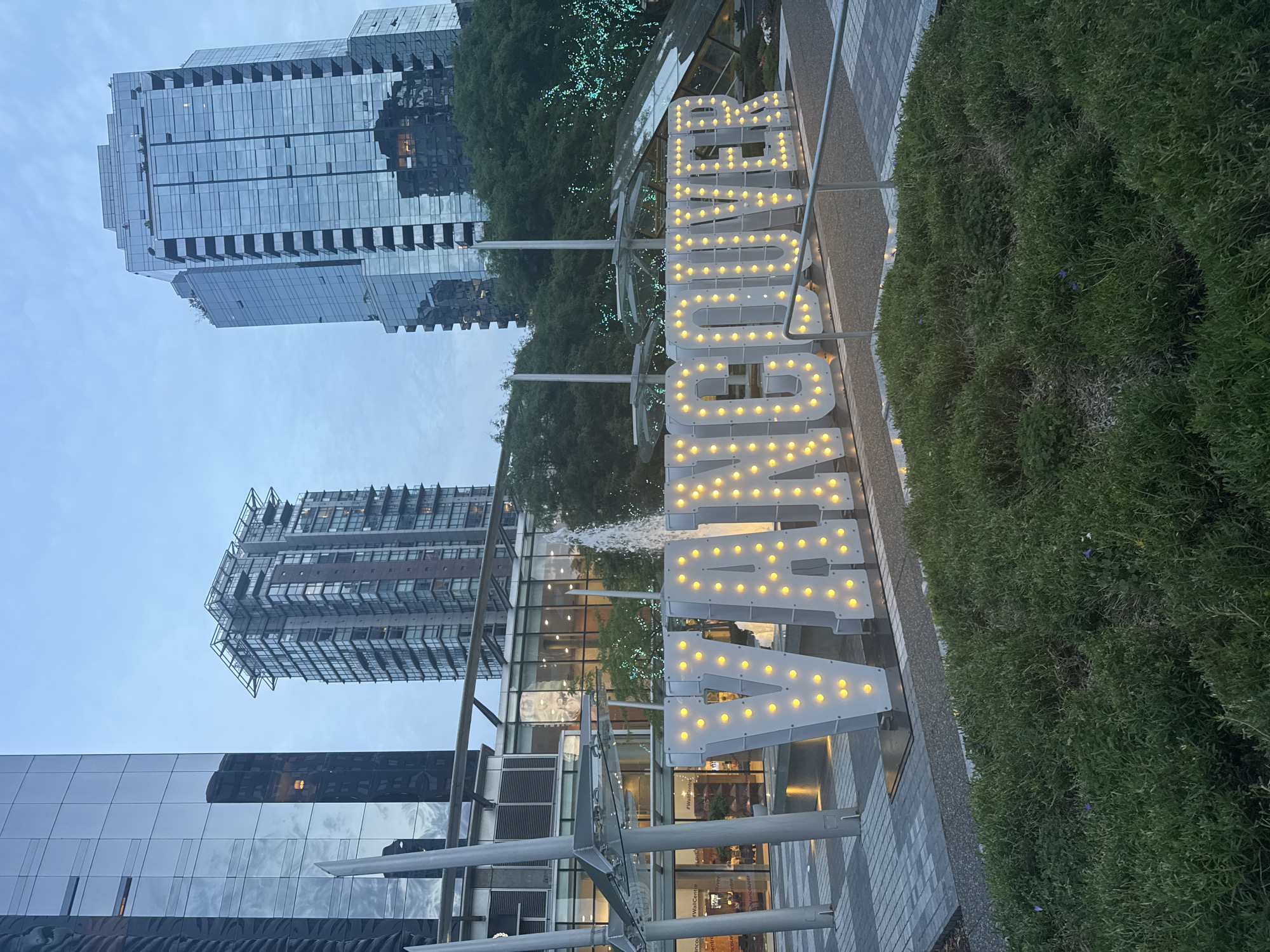 Vancouver's lit plaza sign and skyline at dusk