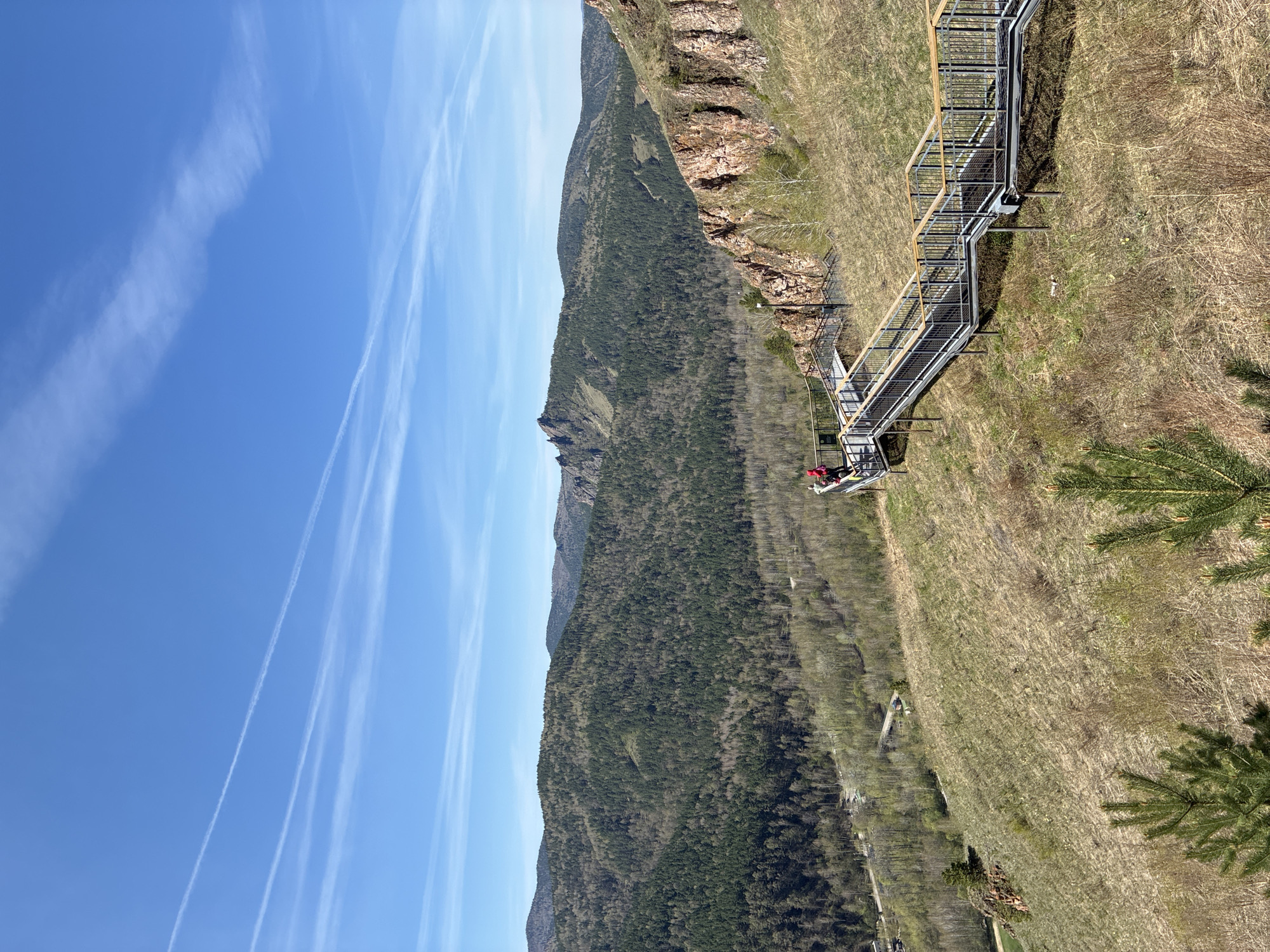 Mountain hikers climb metal stairs amid rocky terrain