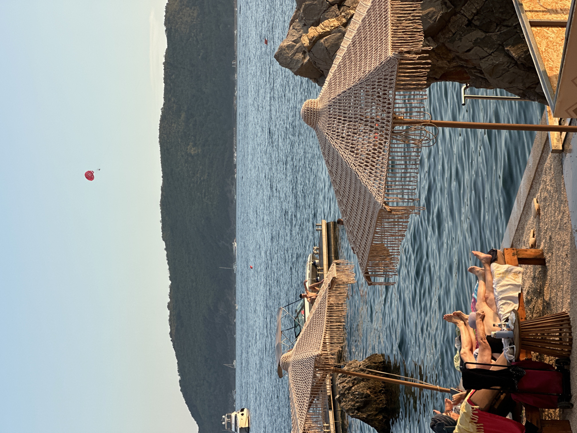 Golden hour beach scene in Budva, parachute overhead