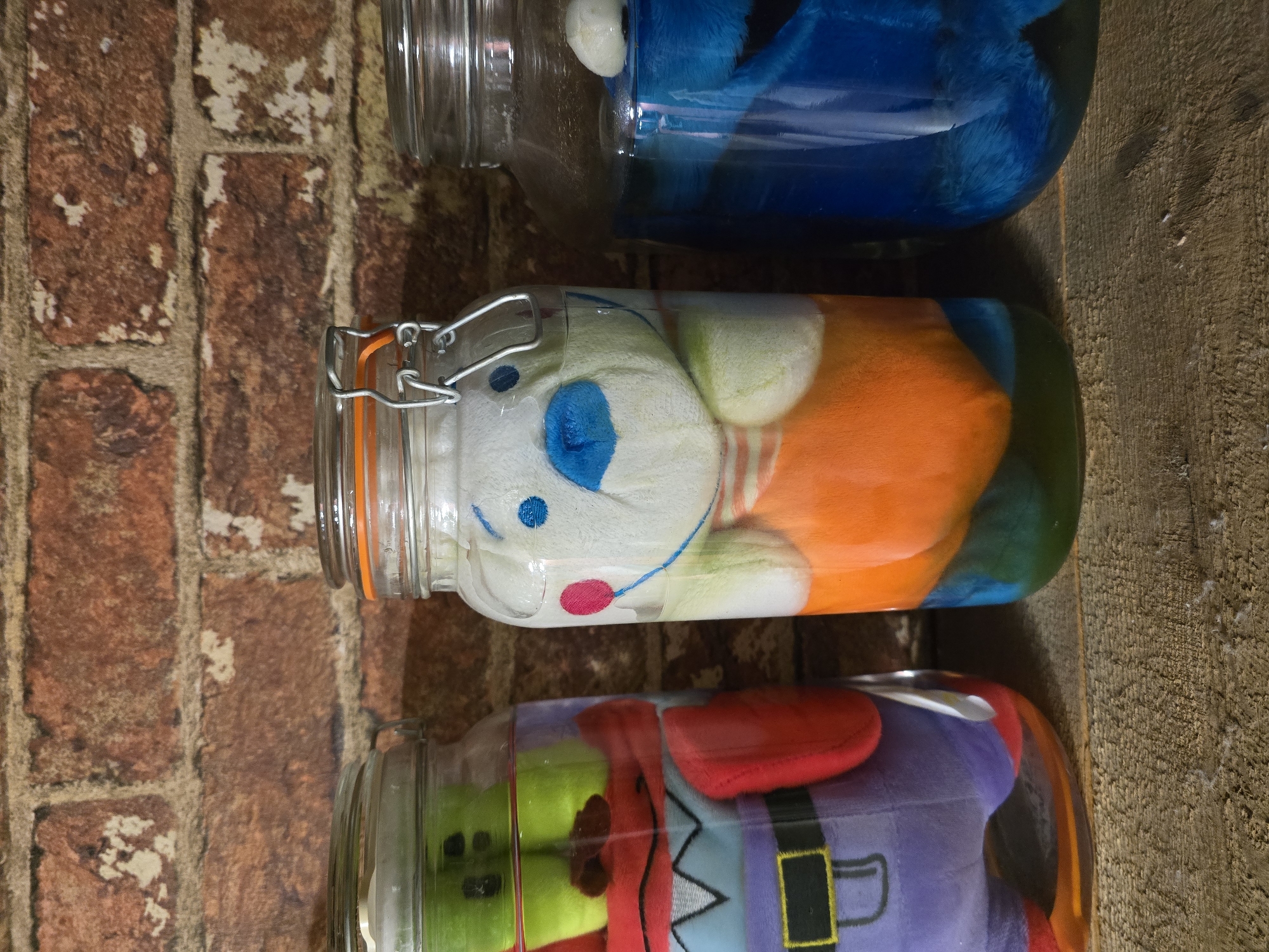Plush toys displayed in glass jars on Yambol wall