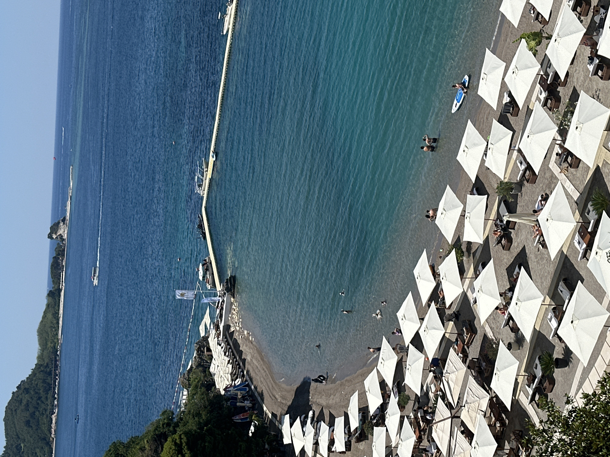 Budva beach and a decorated teal sign, Montenegro