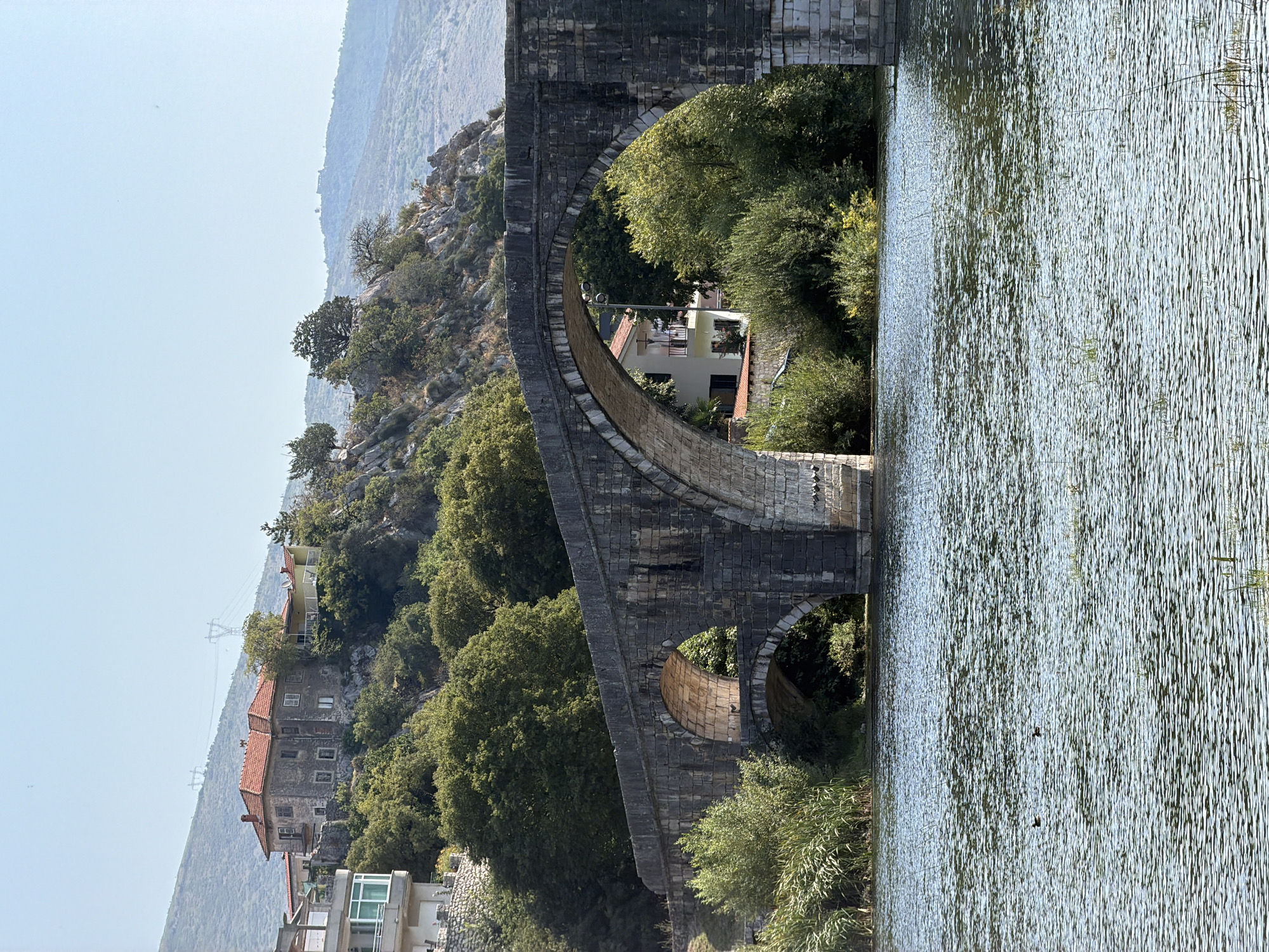 Trebinje's old stone bridge and riverside scenes, summer morning
