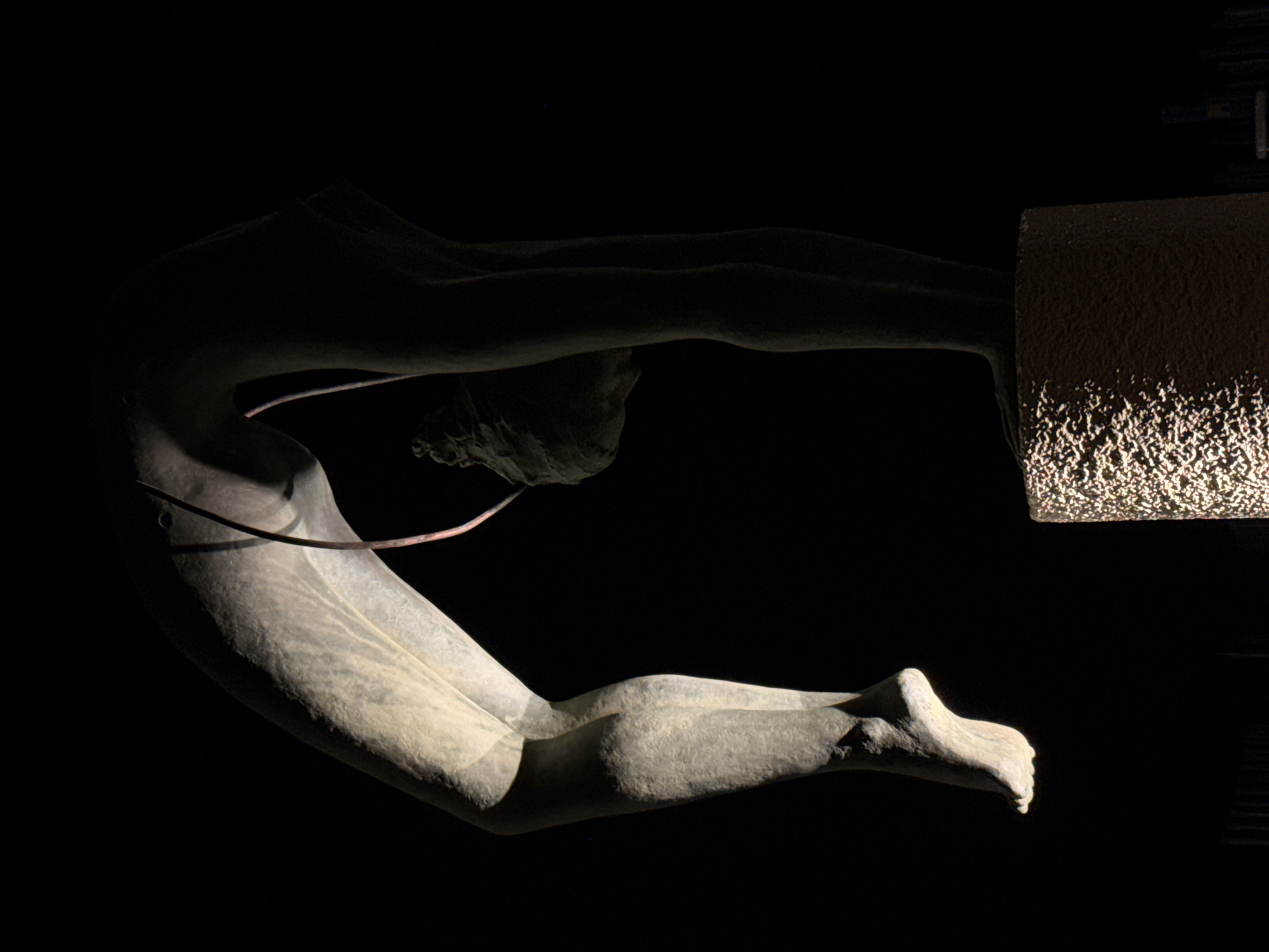 Moonlit beach and bronze acrobat statue on a Latina night