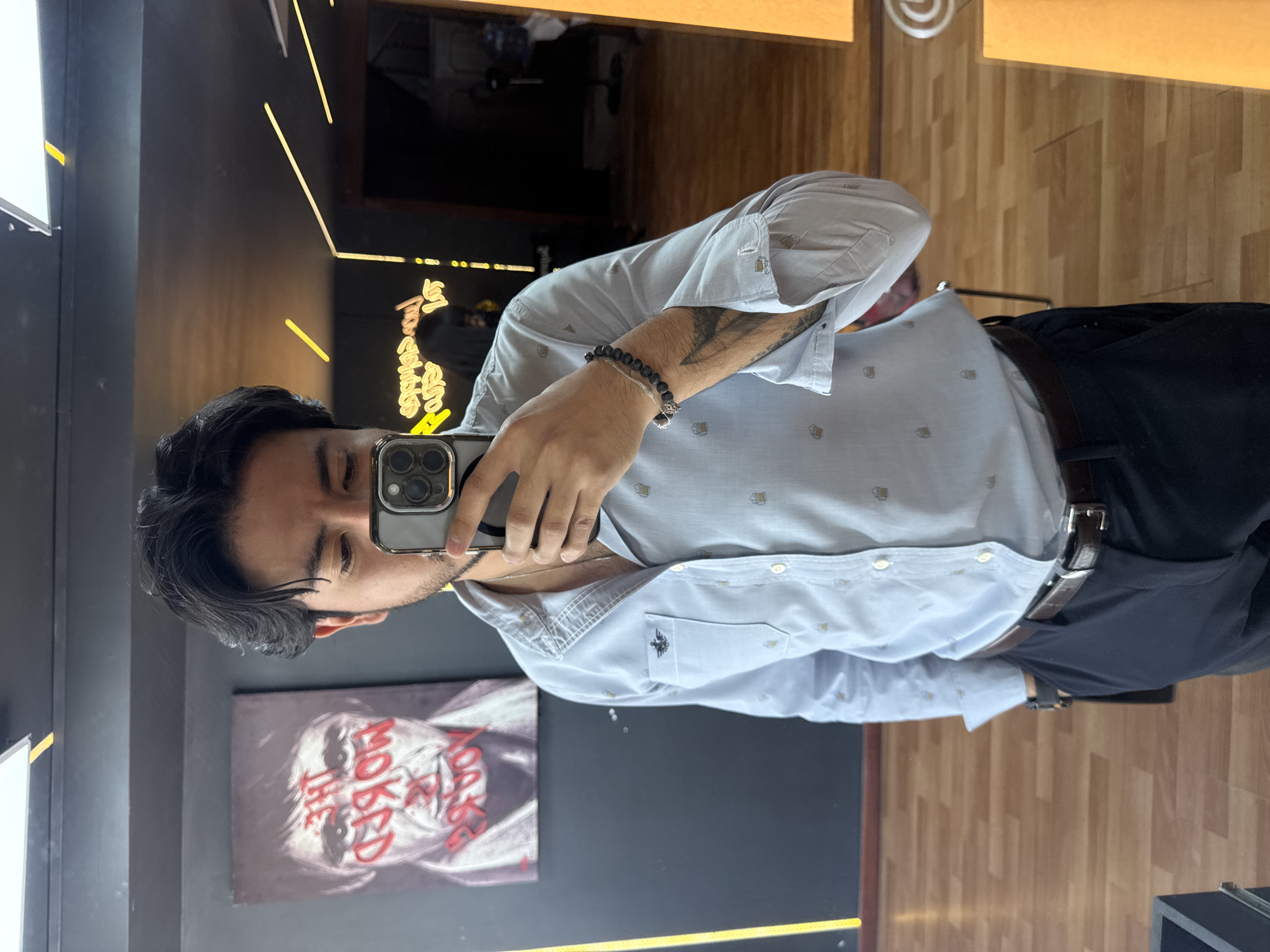 Young man takes mirror selfie at modern Puebla barbershop