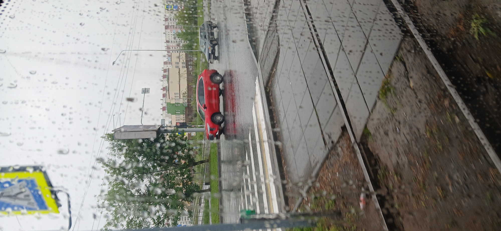 Wet Chelyabinsk streets and rail tracks seen through a rain-streaked window