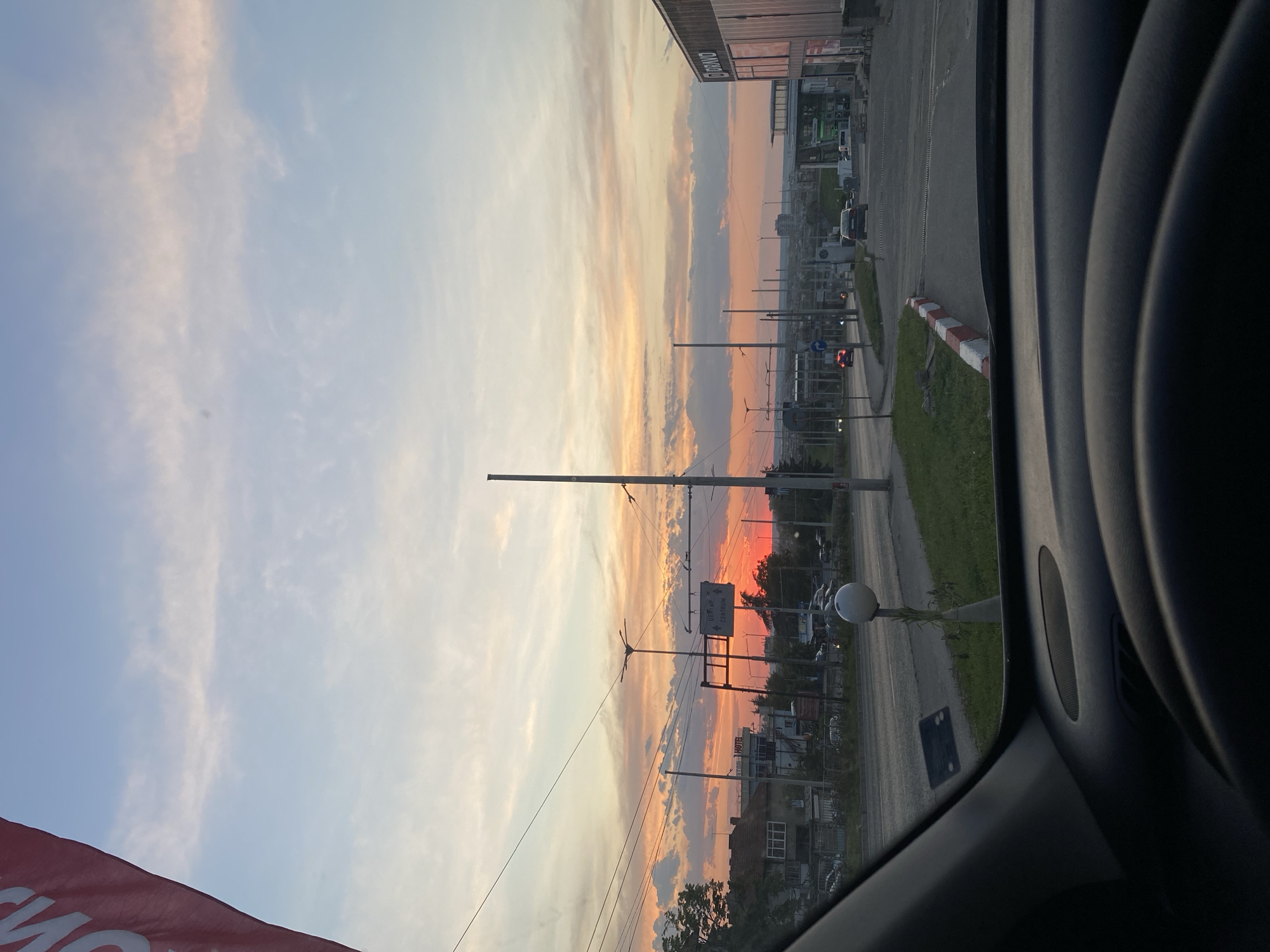 Urban sunset observed from vehicle shows colorful sky gradient