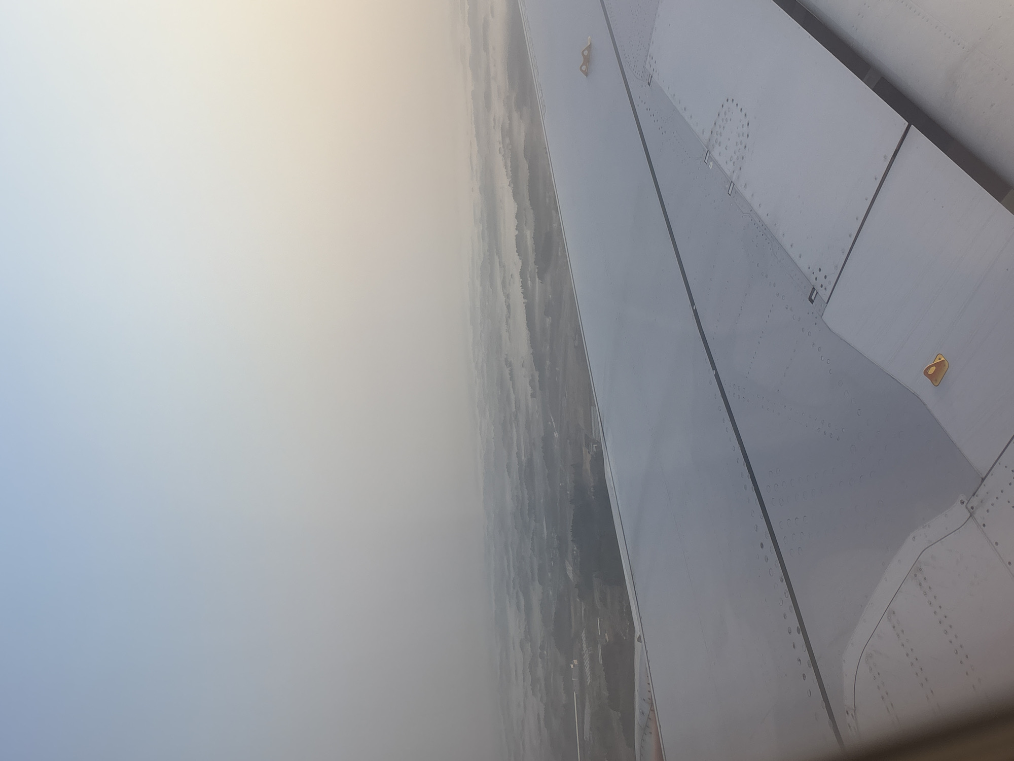 Aircraft passenger documents wing view over hazy Shibayama landscape
