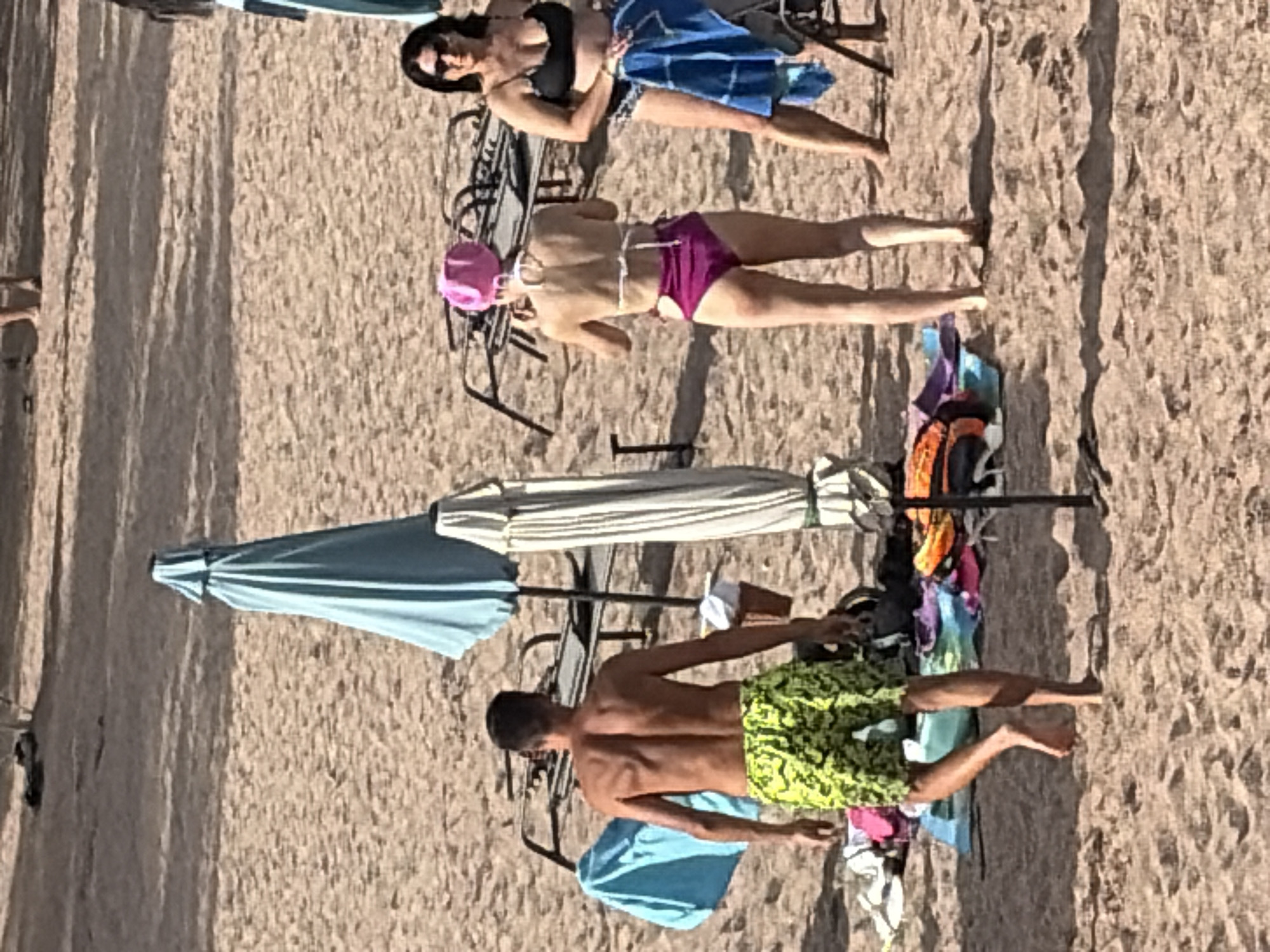 Busy beach day with water activities and mountain backdrop