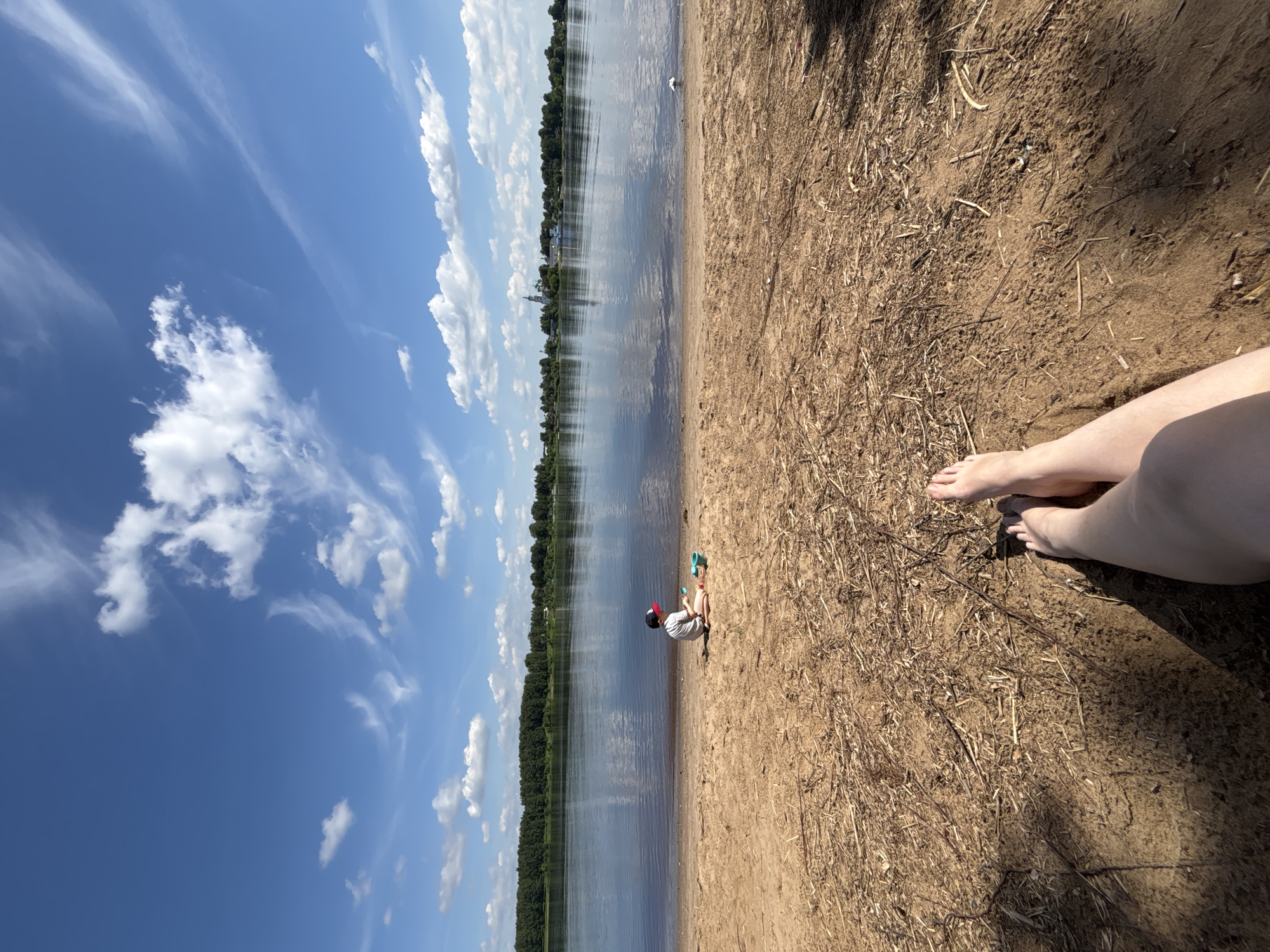Mother and child enjoy sunny morning at Yaroslavl riverfront beach