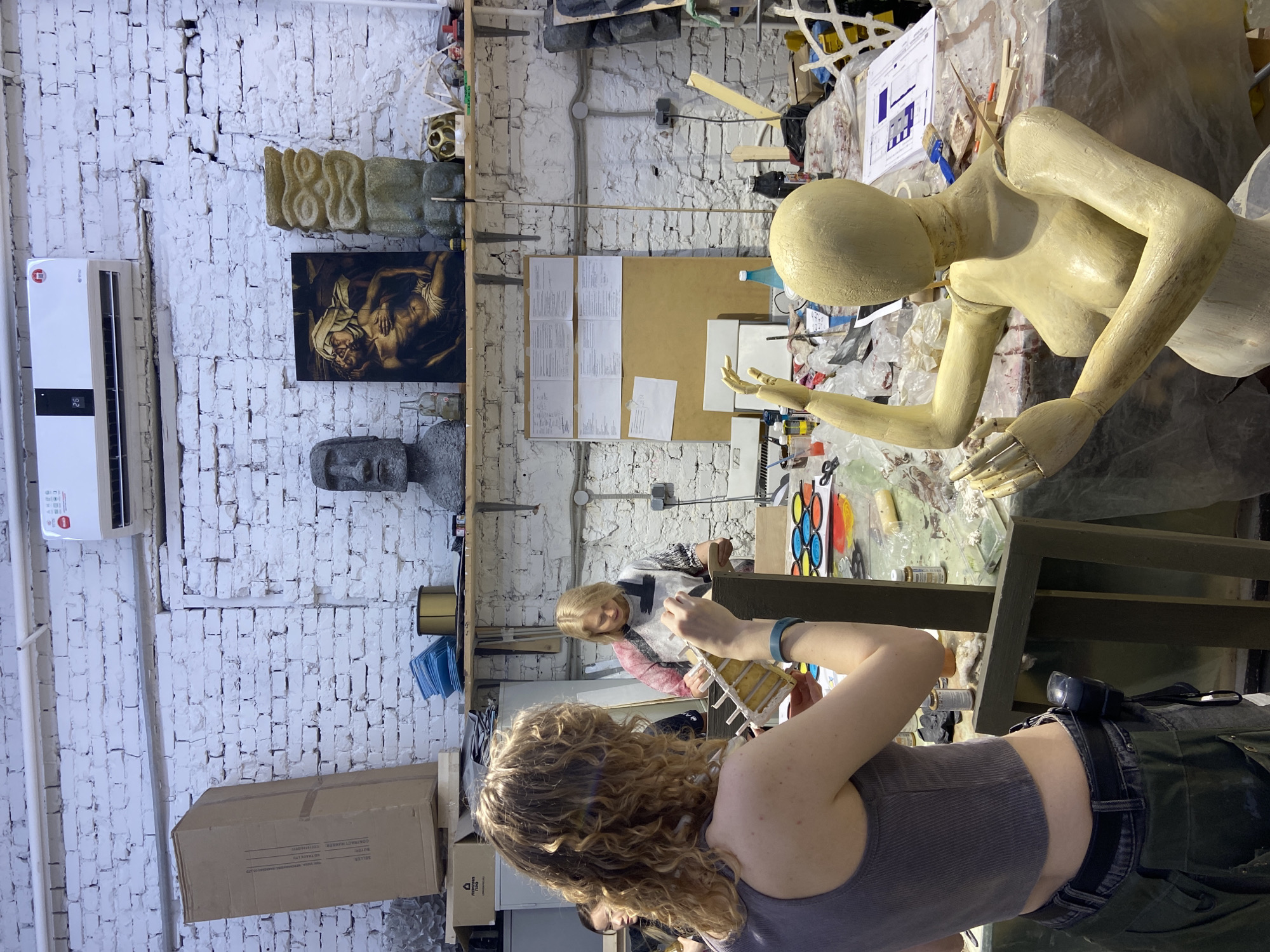 Woman works in bustling Moscow art studio during daylight
