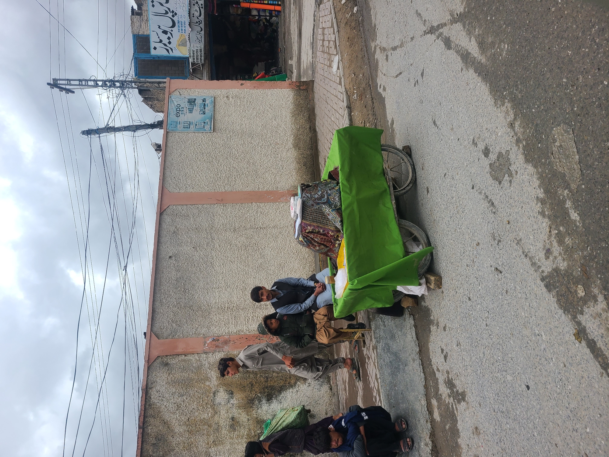 Morning street activity with fabric vendor and motorcycles in Quetta