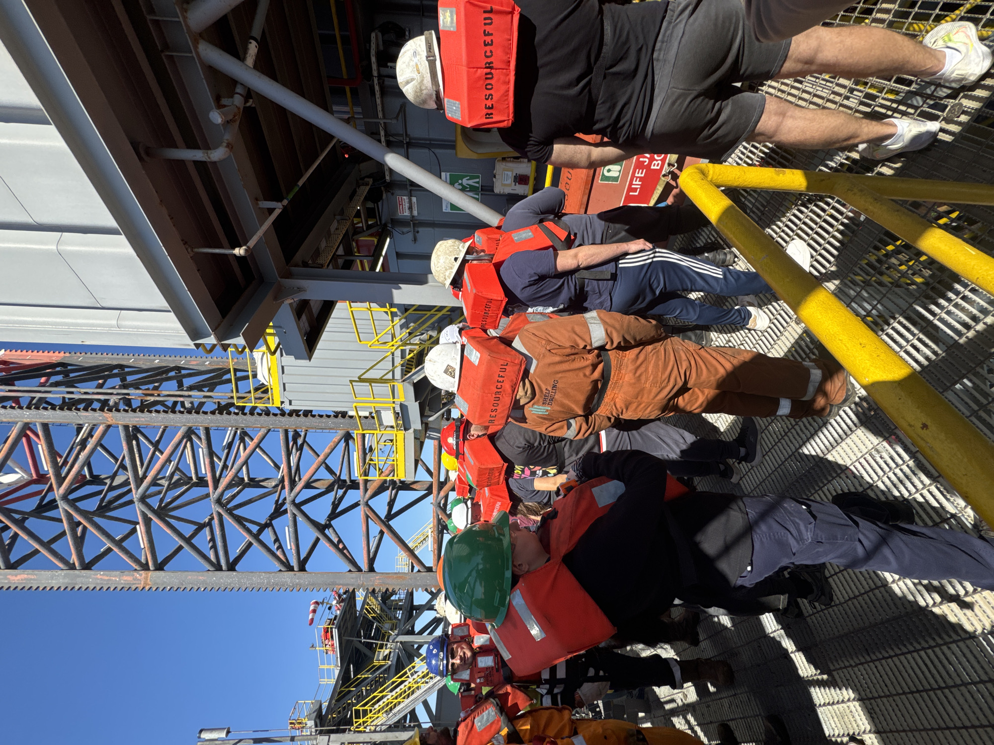 Workers in safety gear gathered on metal platform in Italy