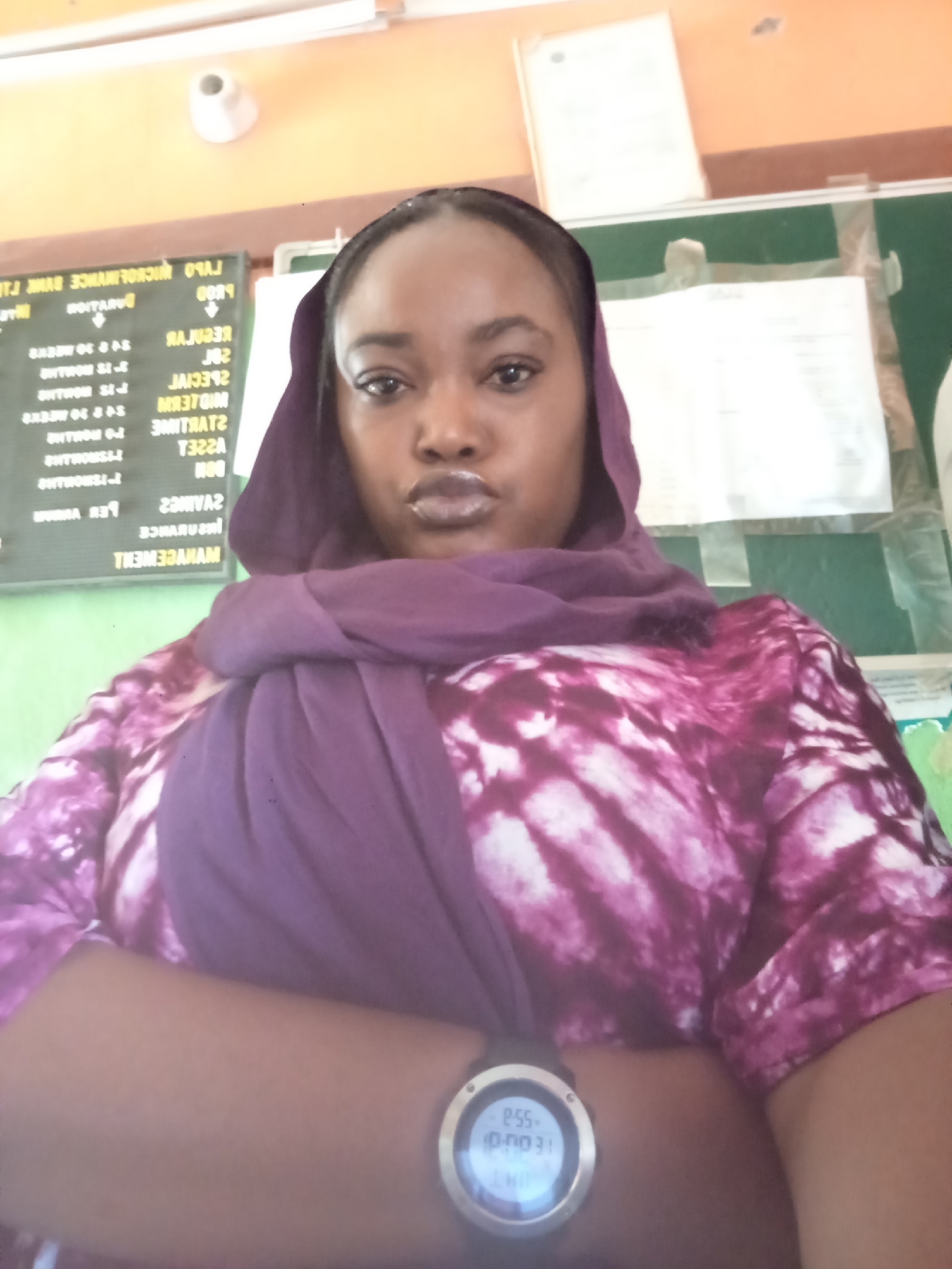 Woman takes selfie wearing purple headscarf and tie-dye shirt
