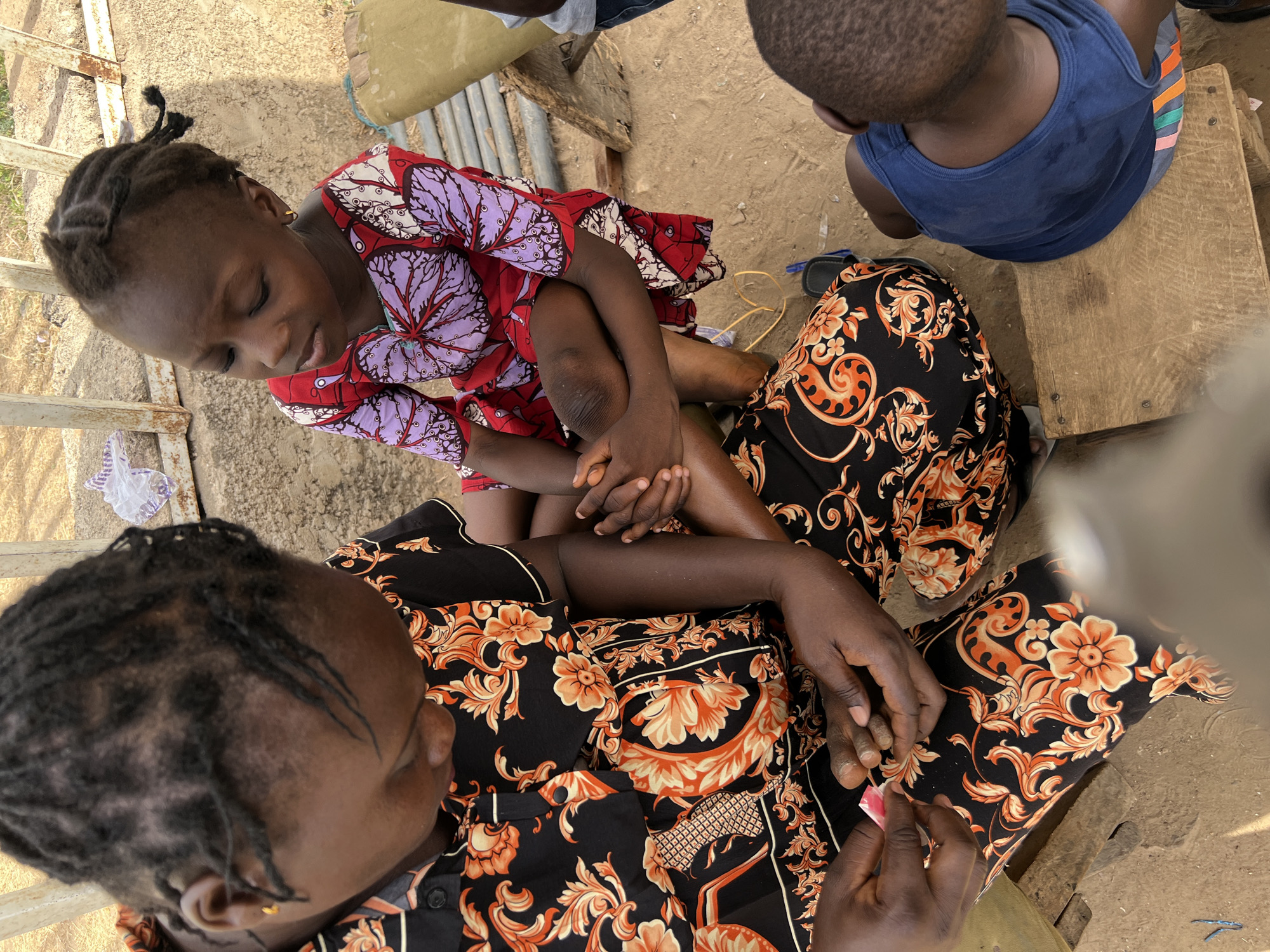 Everyday moments captured in Minna: child with woman, man carrying box