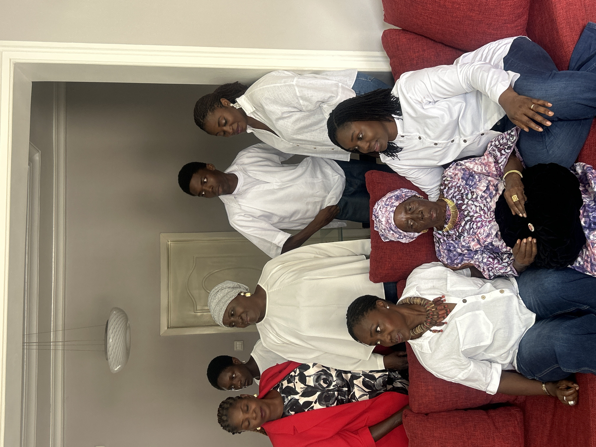 Group portrait session on a red couch in Jos home