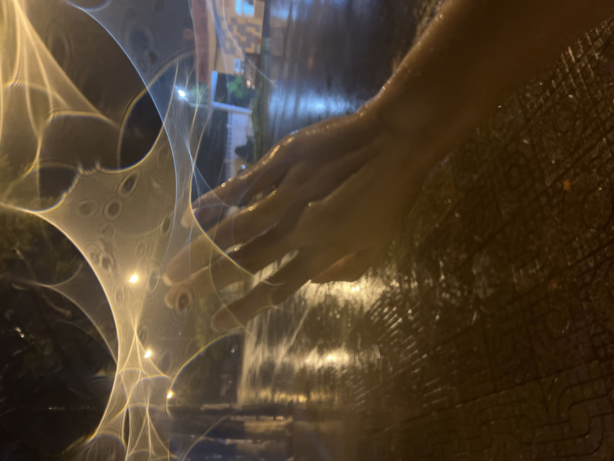 Hand gesture captured over wet pavement in Vietnam
