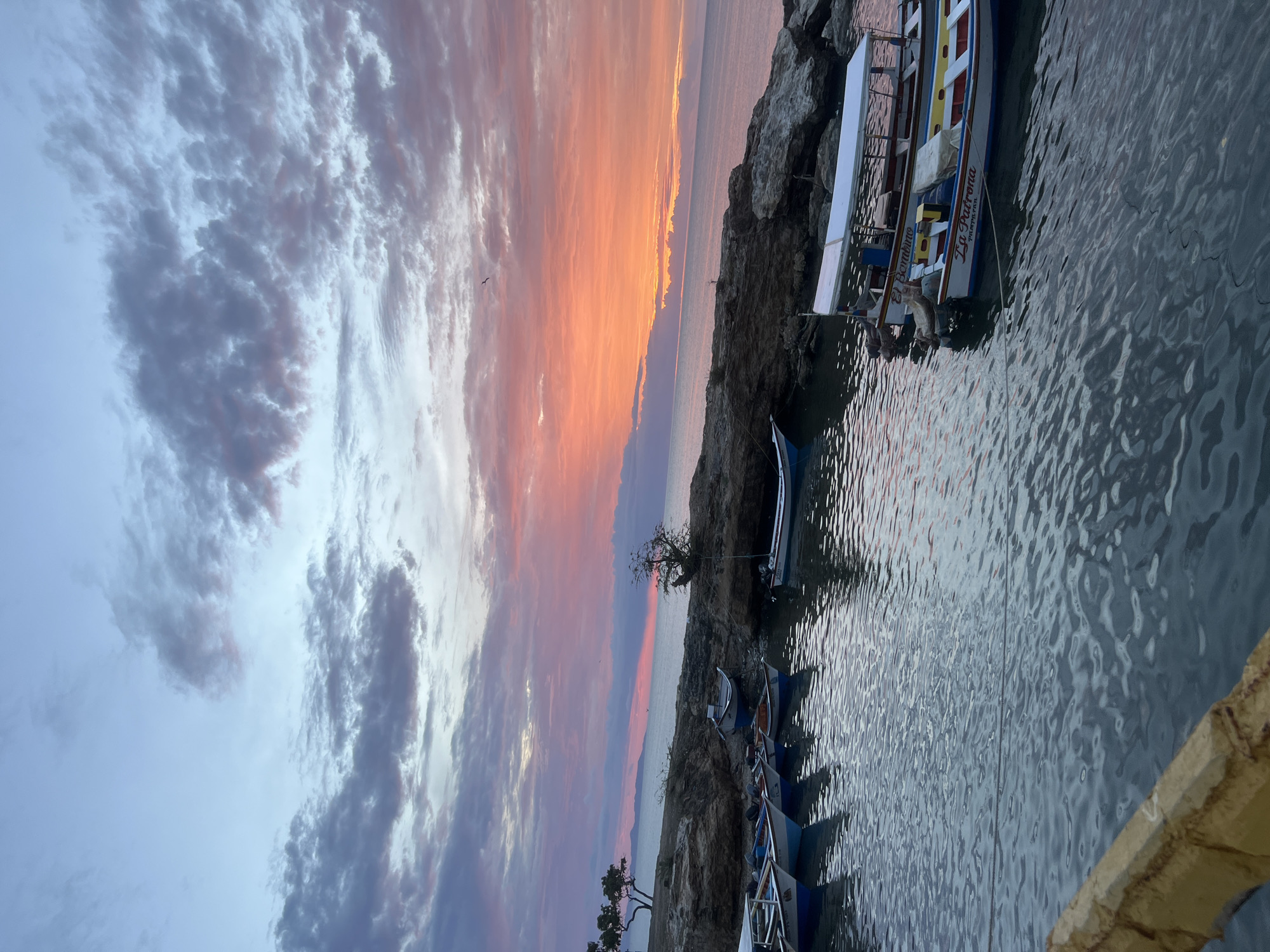Sunset along Juan Griego's waterfront, boats and crowds at dusk
