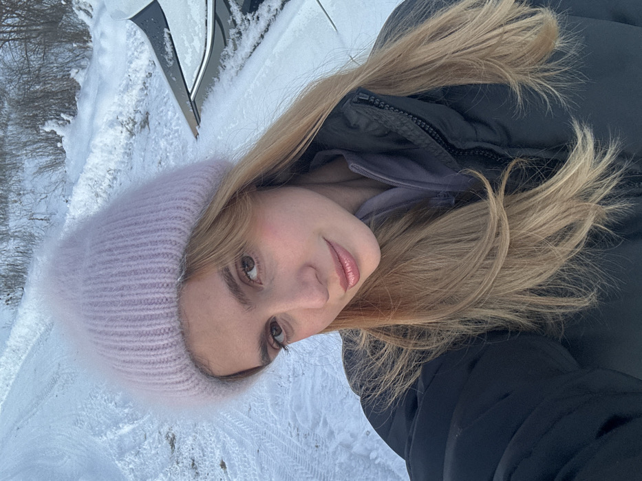 Woman photographed in snowy twilight setting during winter
