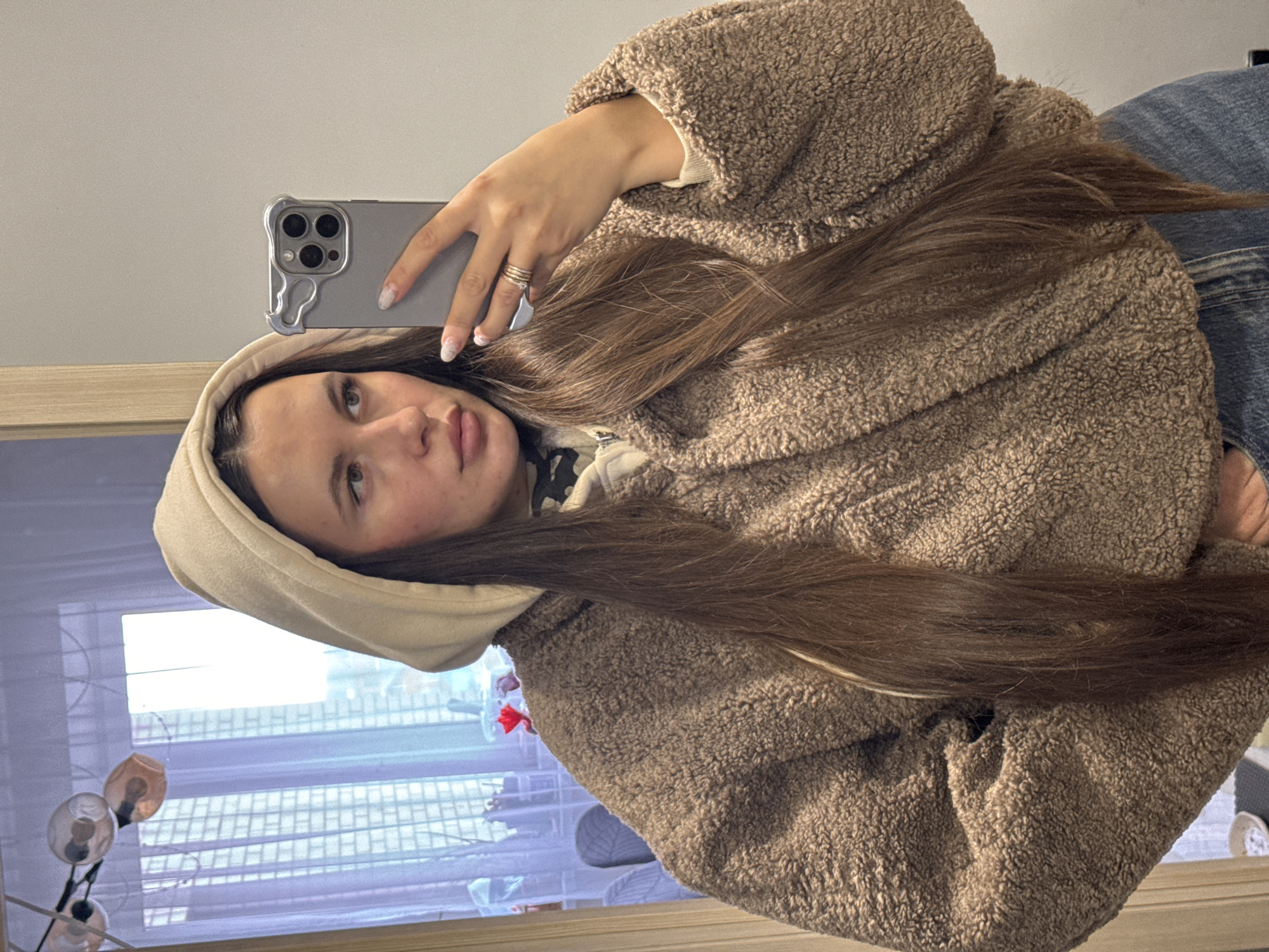 Woman takes selfies in brown hoodie in Odintsovo
