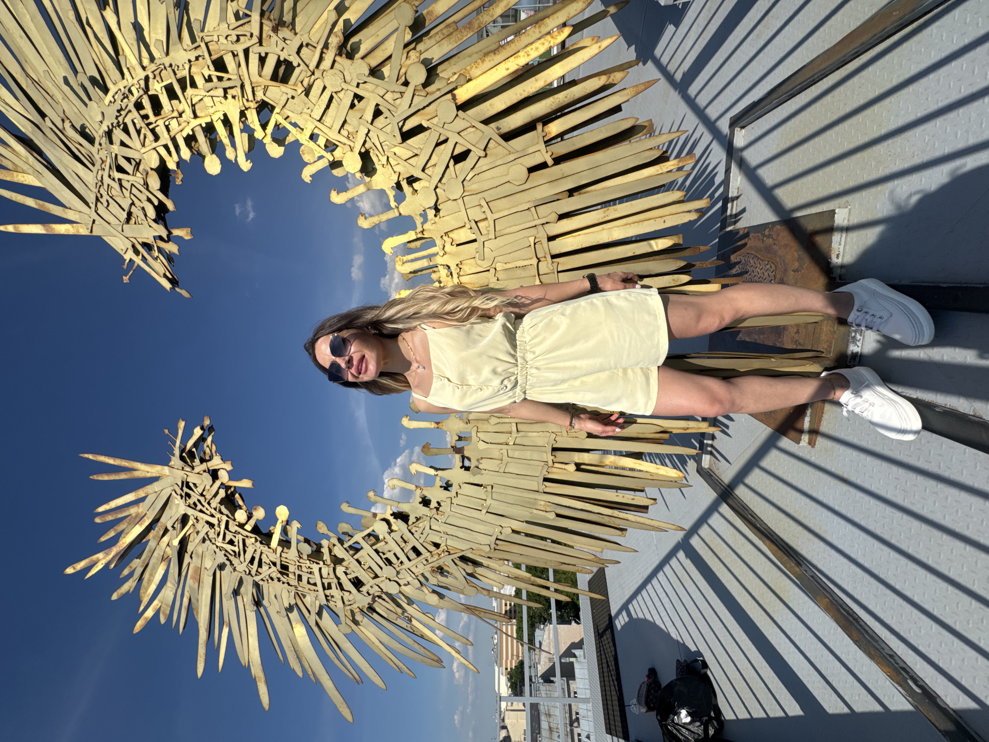 Woman poses with drinks at Saint Petersburg rooftop sculpture