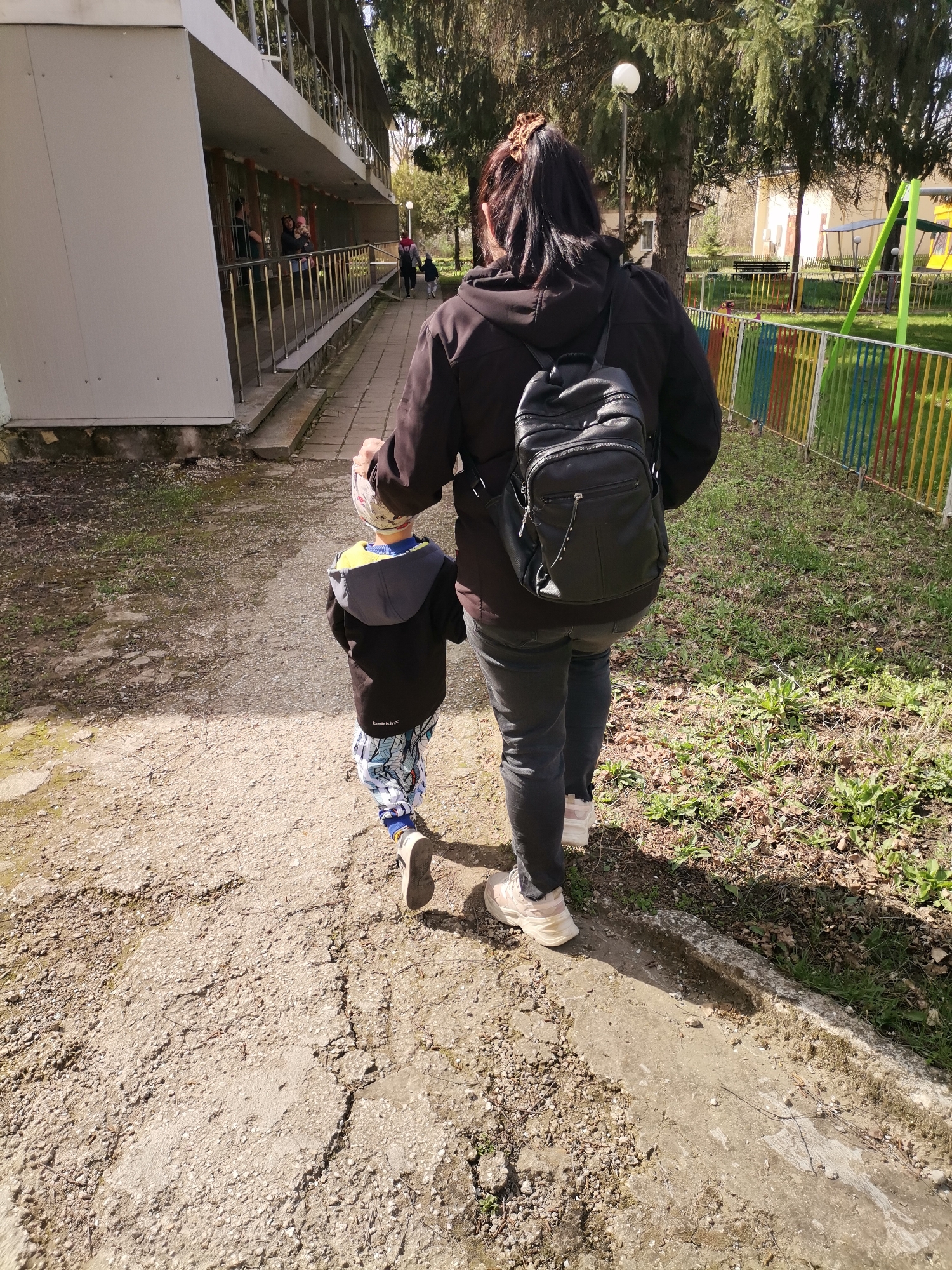 Woman, child walk morning path in Dobrich, Bulgaria