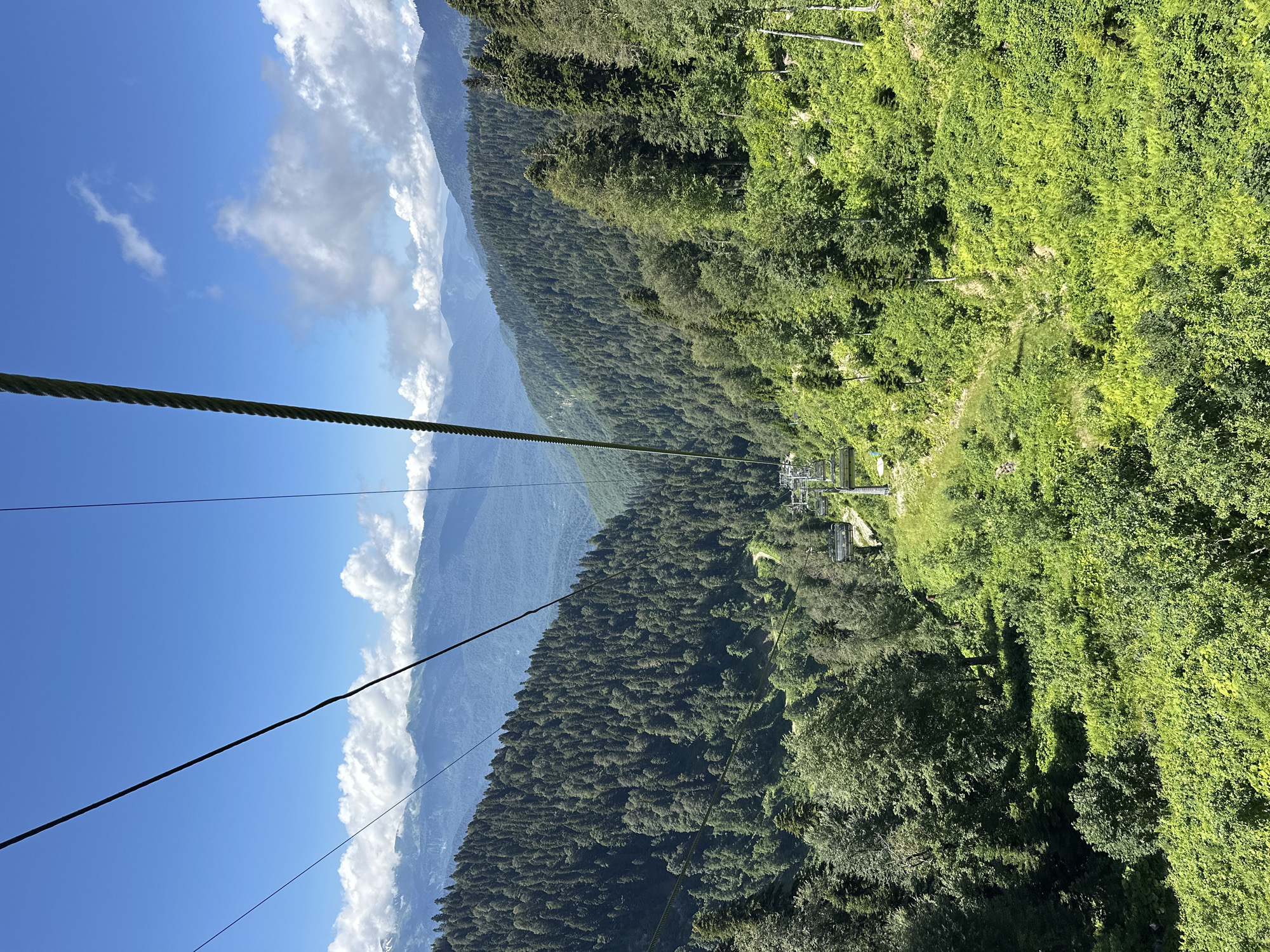 Cable car ascending forested mountain slopes in Estosadok, Russia