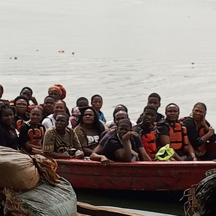 Crowded red boat carries 20+ adults on water