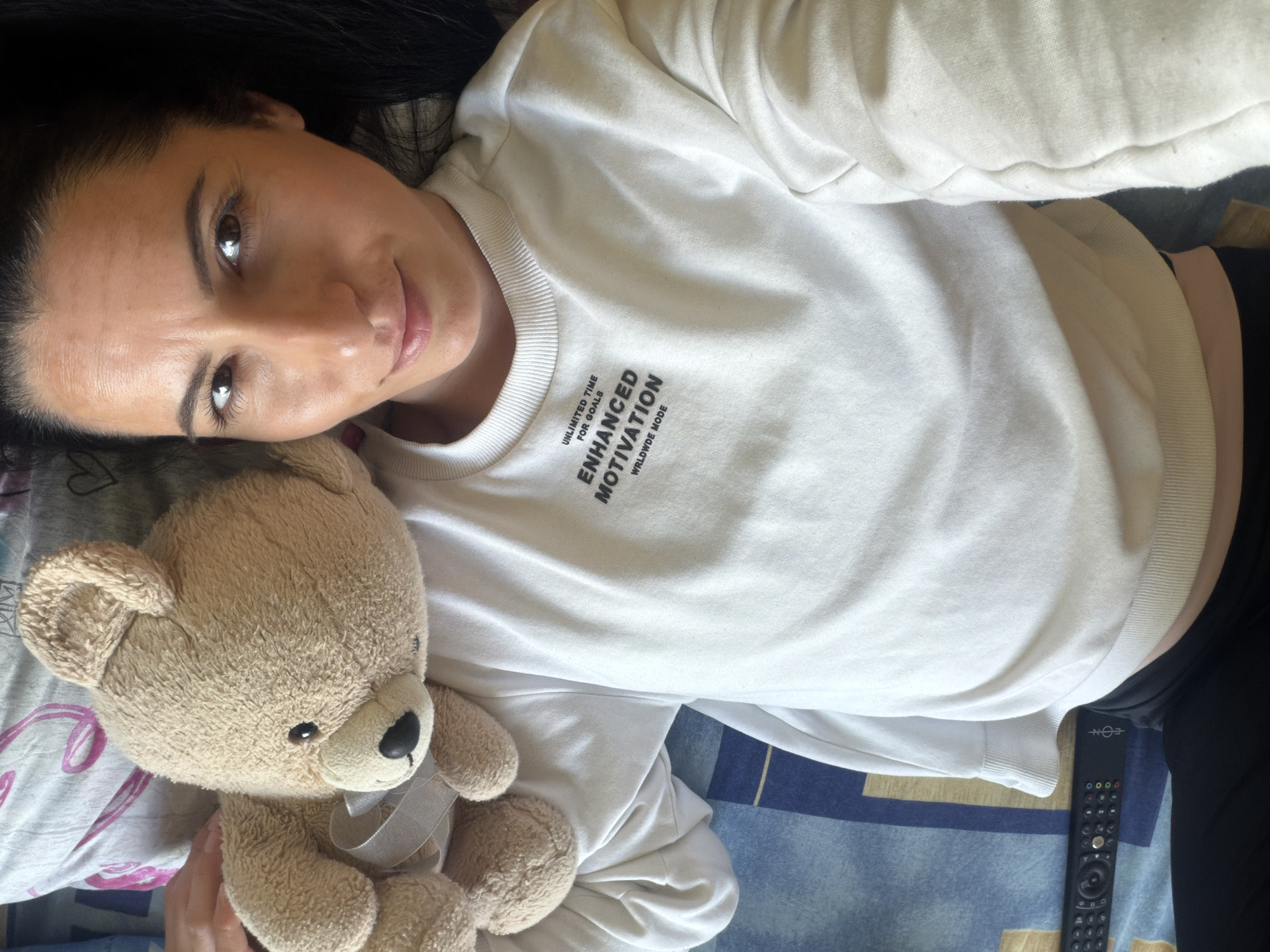 Woman rests with teddy bear on bed in Pleven