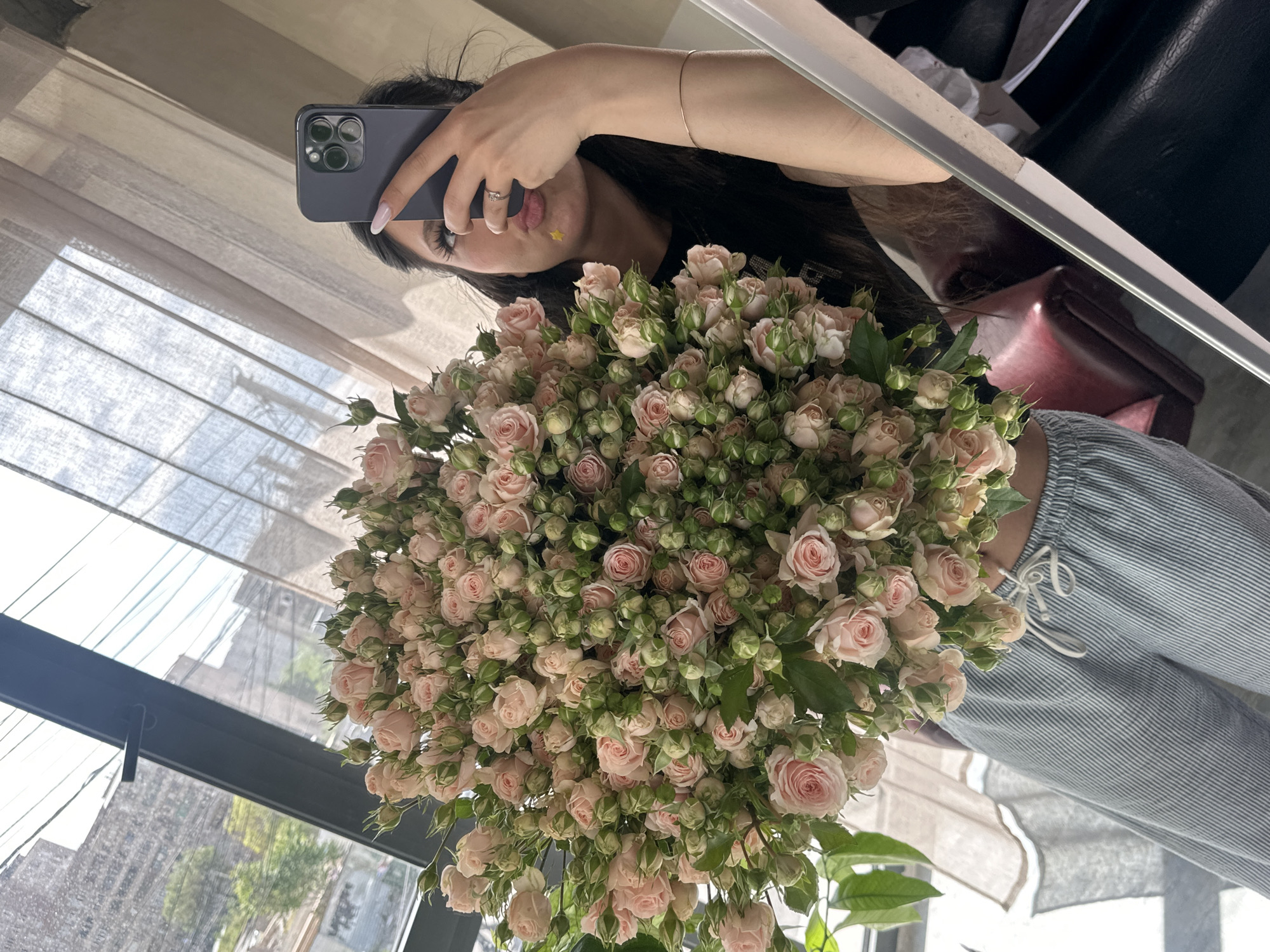 Person takes mirror selfie with pink rose bouquet in Armenia