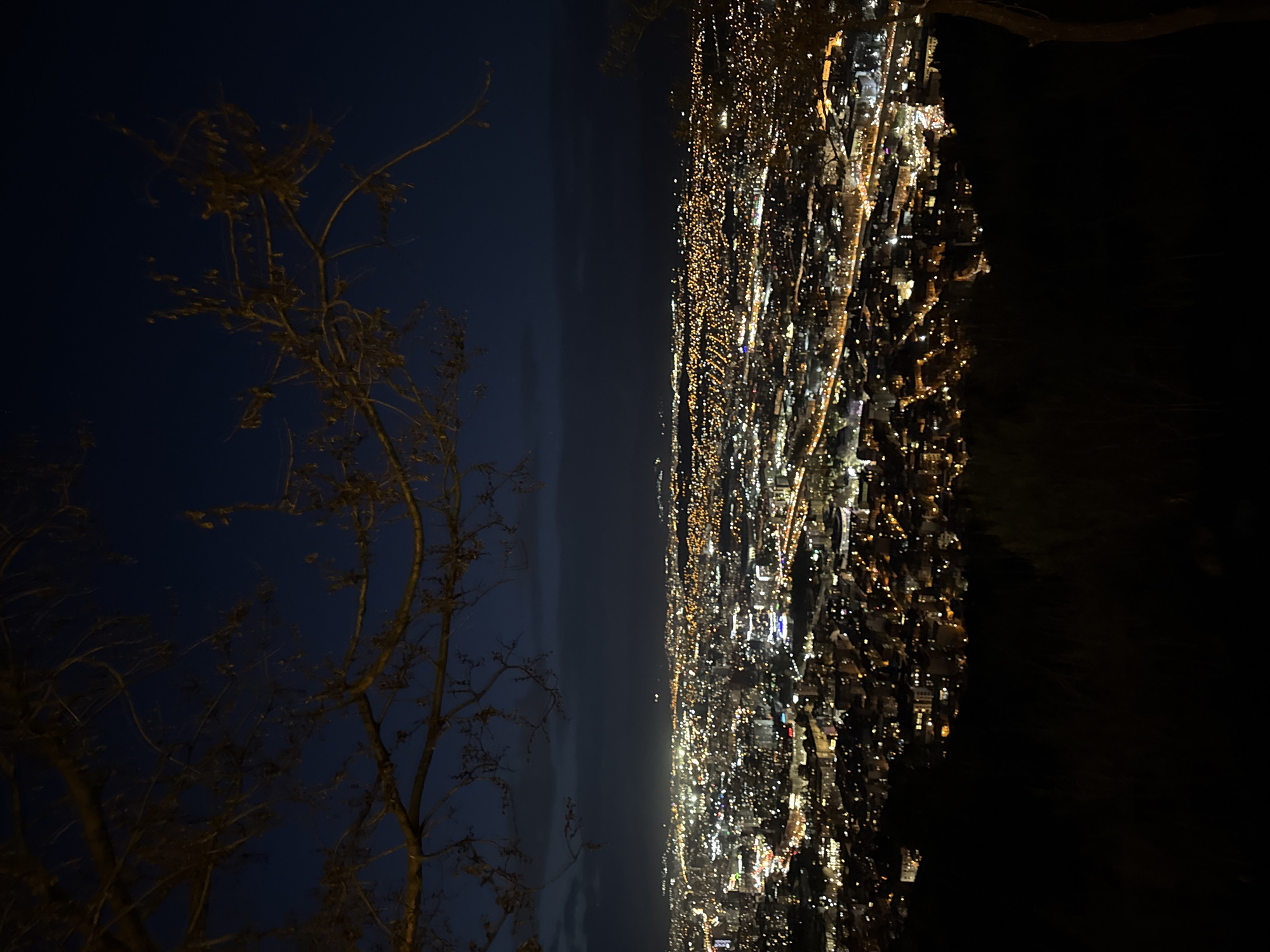 Nighttime aerial view captures illuminated Tbilisi cityscape