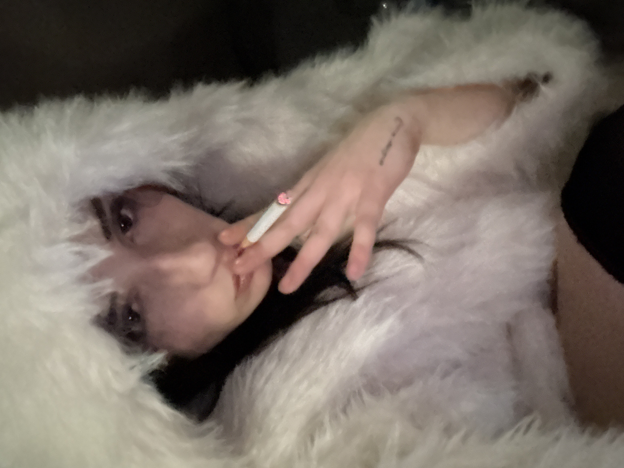 Person in white fur coat smokes on Buenos Aires balcony