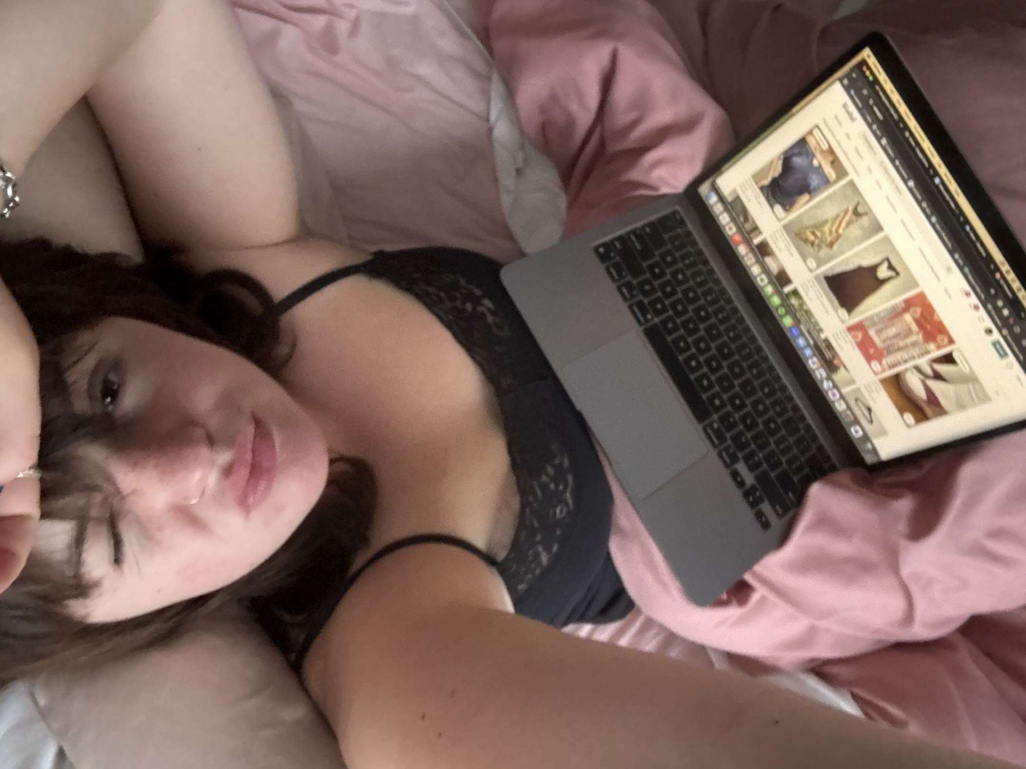 Woman relaxes with laptop in bed in Cortona